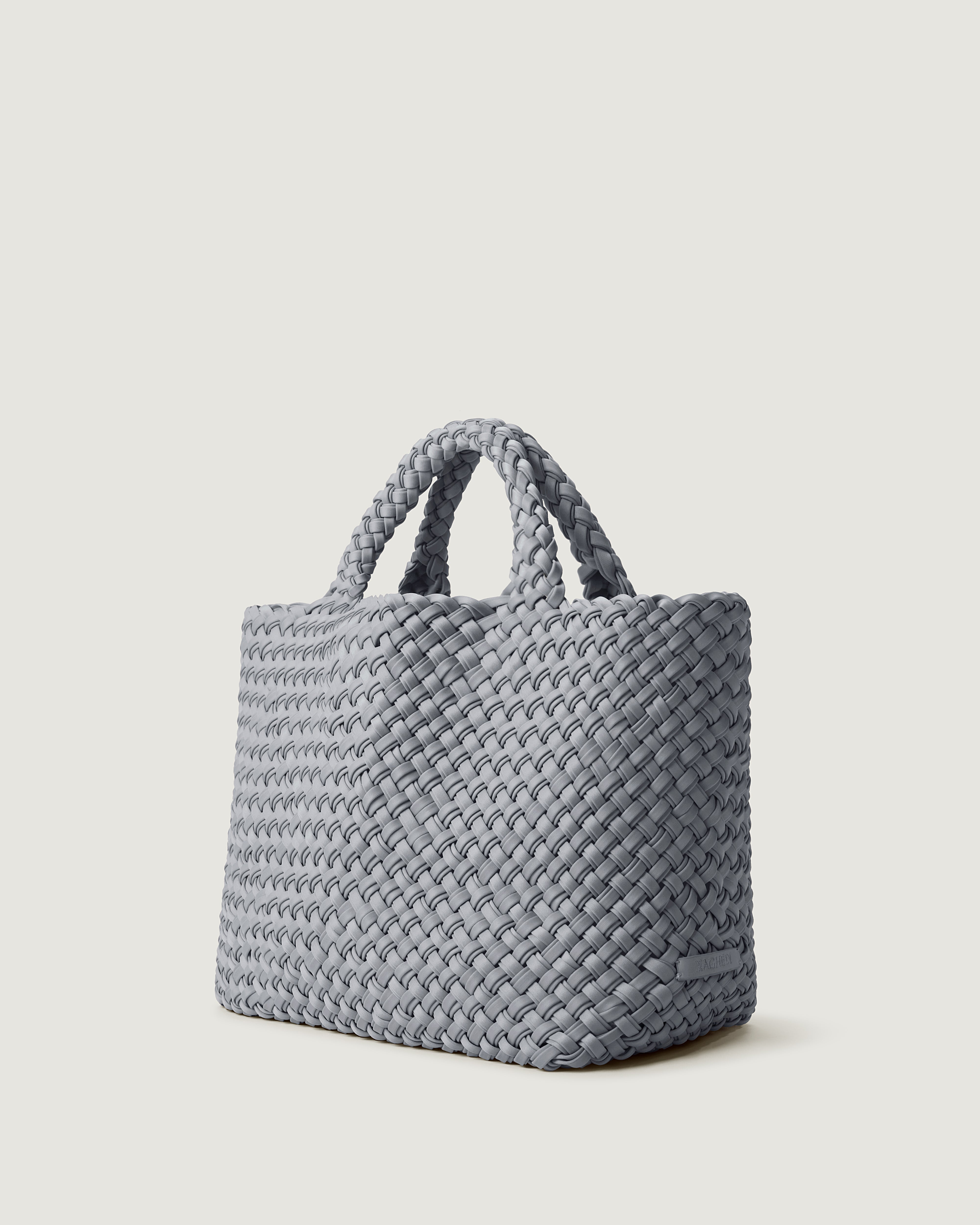 St. Barths Tote in Marina shown from a side angle, highlighting its handwoven neoprene construction and open top.