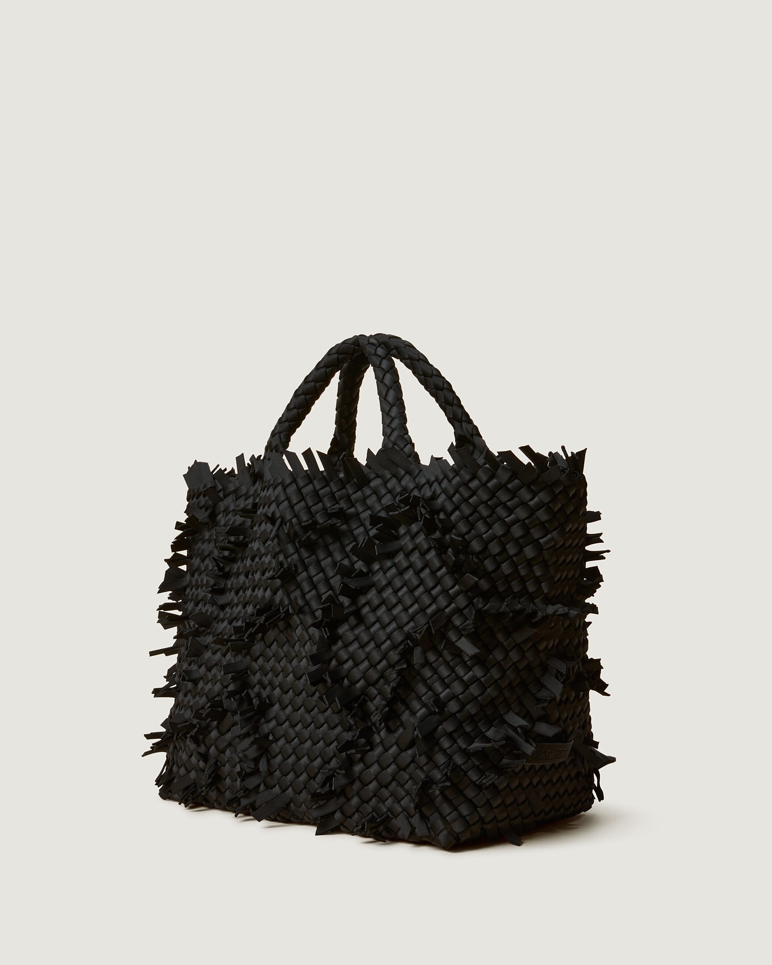 St. Barths Tote in Onyx shown from a side angle, highlighting its handwoven neoprene construction and open top.