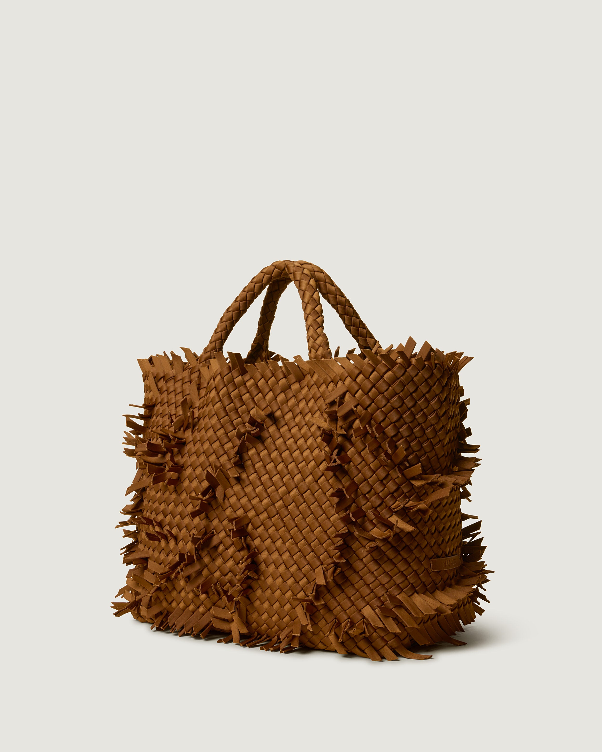 St. Barths Tote in Teak shown from a side angle, highlighting its handwoven neoprene construction and open top.