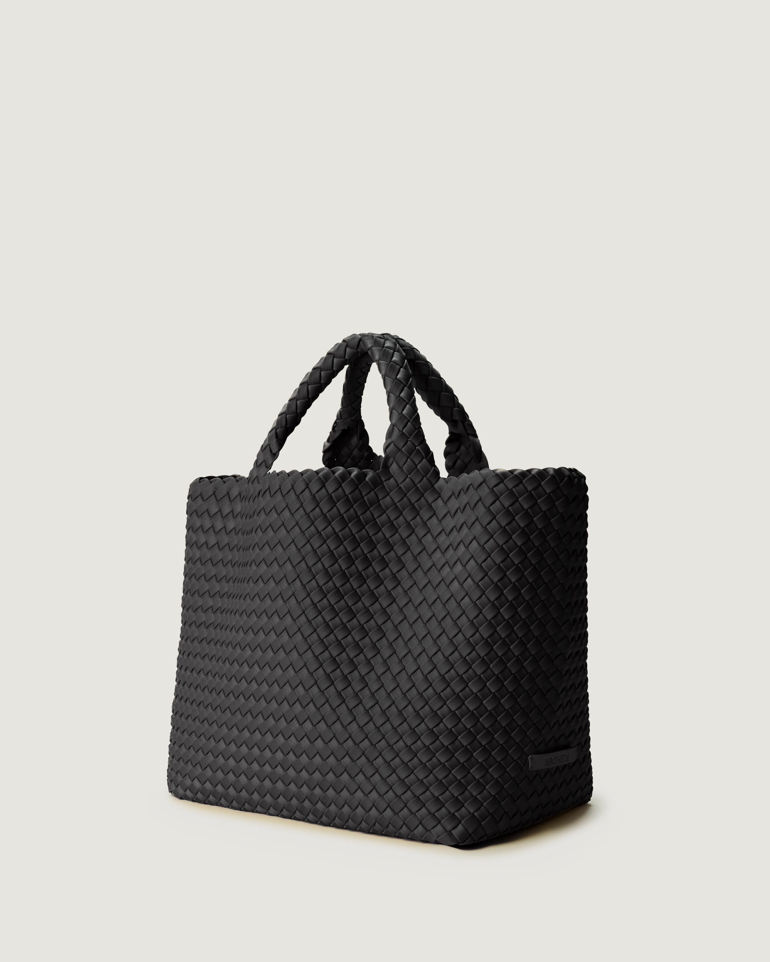 St. Barths Tote in Ash shown from a side angle, highlighting its handwoven neoprene construction and open top.