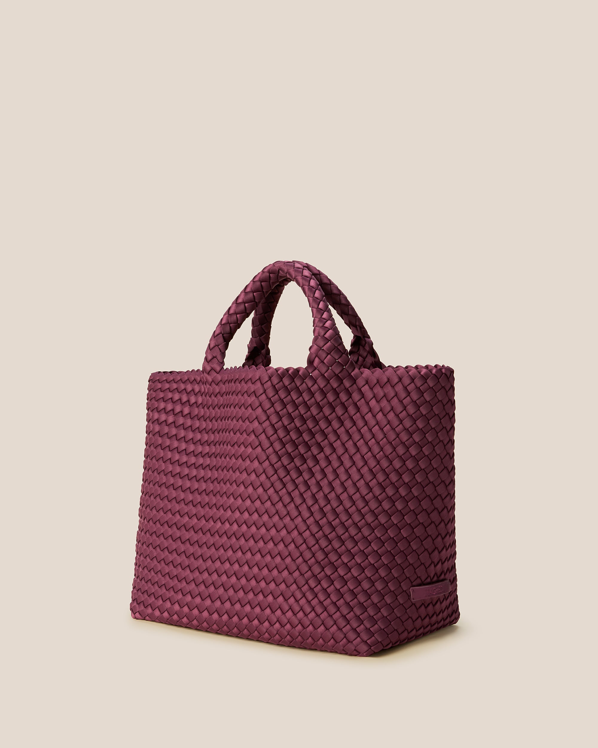 St. Barths Medium Tote Bag in Bordeaux shown from a side angle, highlighting its handwoven neoprene and open top.