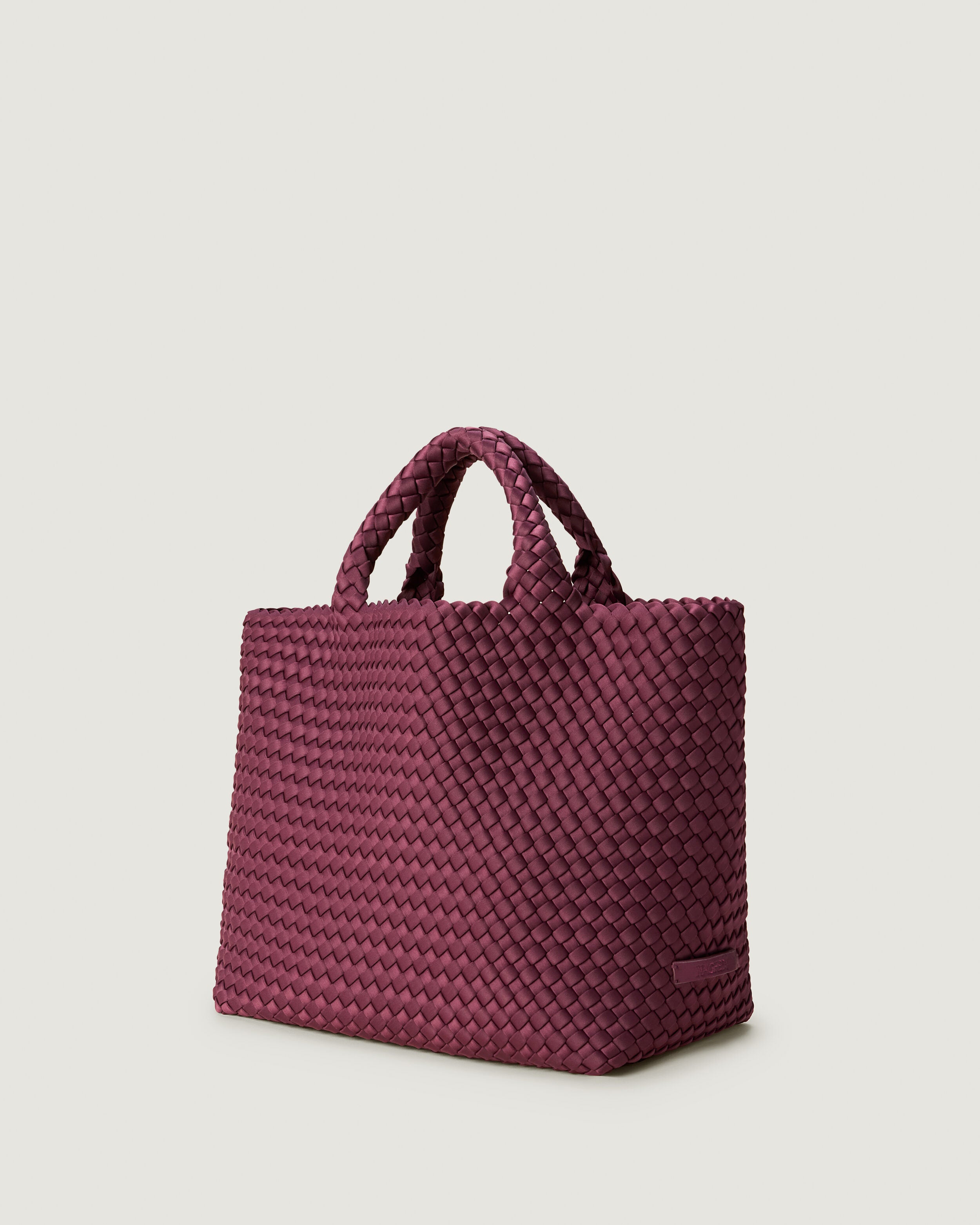 St. Barths Tote in Bordeaux shown from a side angle, highlighting its handwoven neoprene construction and open top.