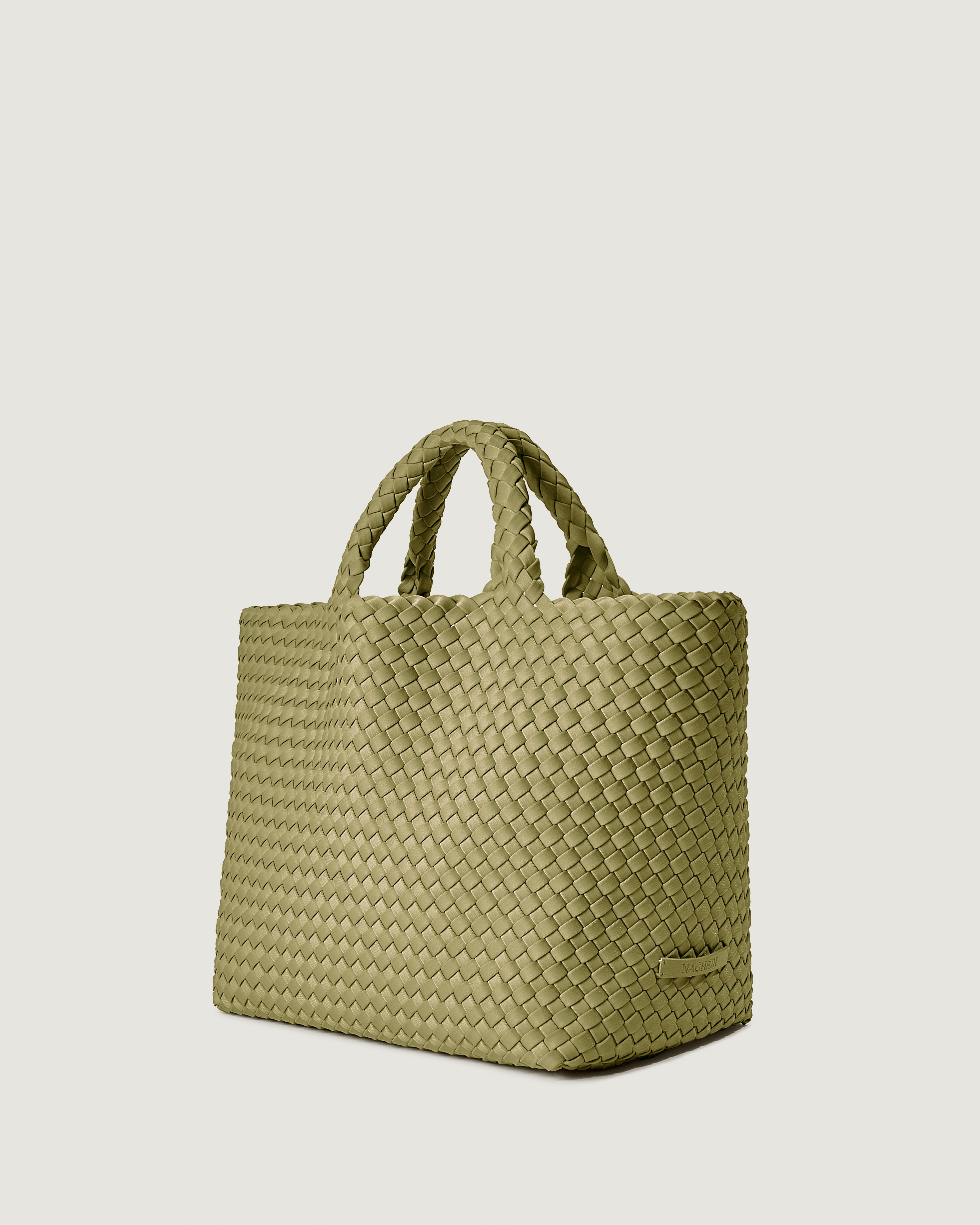 St. Barths Tote in Bottle Green shown from a side angle, highlighting its handwoven neoprene construction and open top.