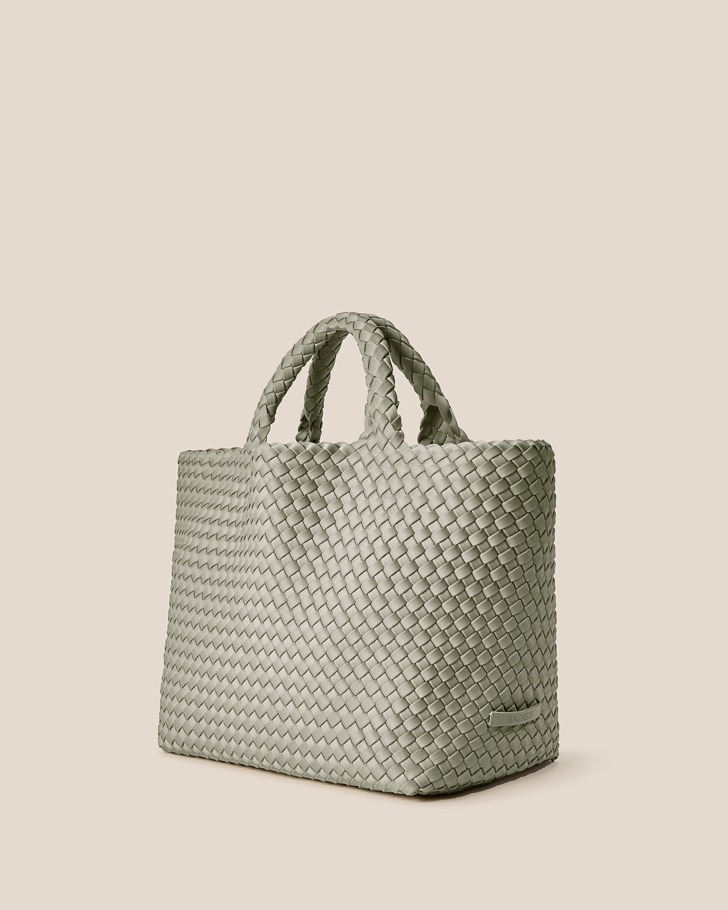 St. Barths Tote in Celadon shown from a side angle, highlighting its handwoven neoprene construction and open top.