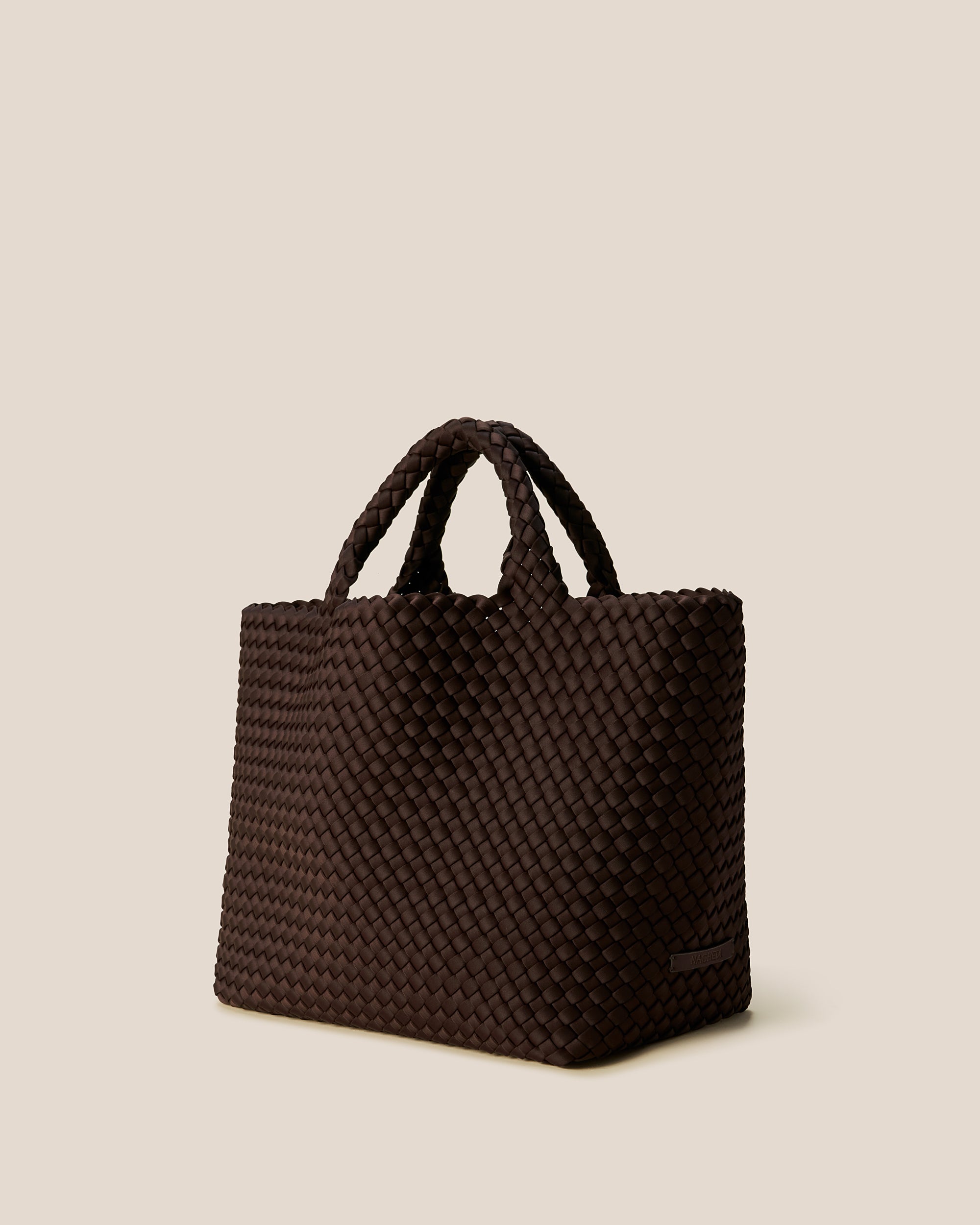 St. Barths Medium Tote Bag in Chocolate shown from a side angle, highlighting its handwoven neoprene and open top.