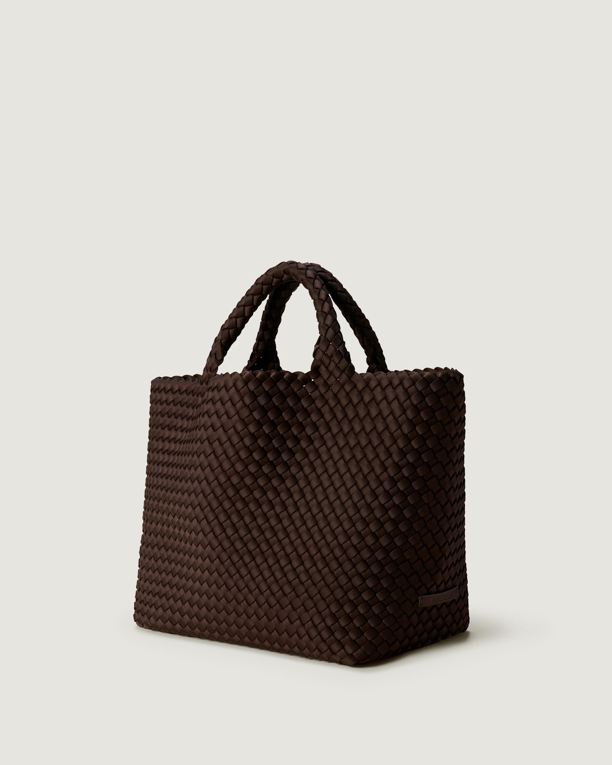 St. Barths Tote in Chocolate shown from a side angle, highlighting its handwoven neoprene construction and open top.