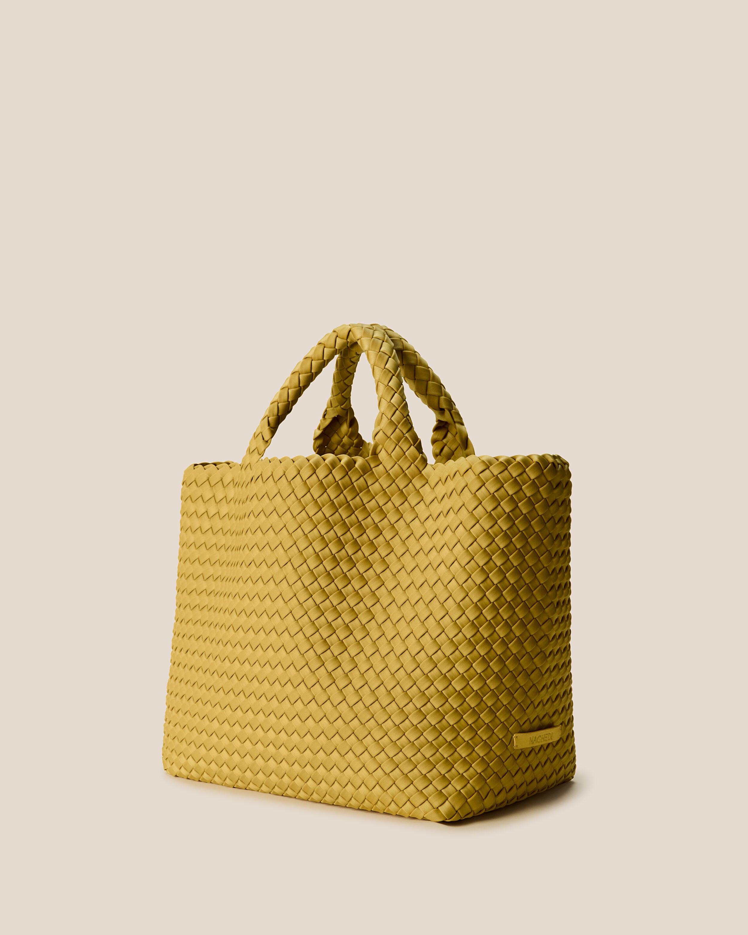 St. Barths Tote in Citrine shown from a side angle, highlighting its handwoven neoprene construction and open top.