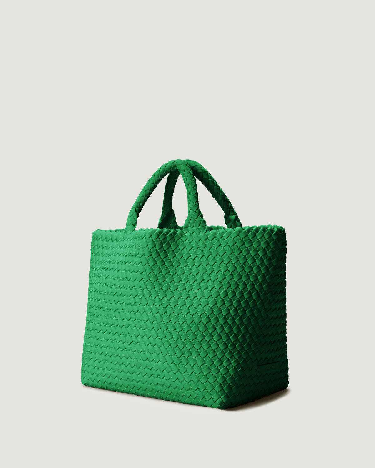 St Barths Tote in Emerald shown from a side angle, highlighting its handwoven neoprene construction and open top with magnetic snap closure.