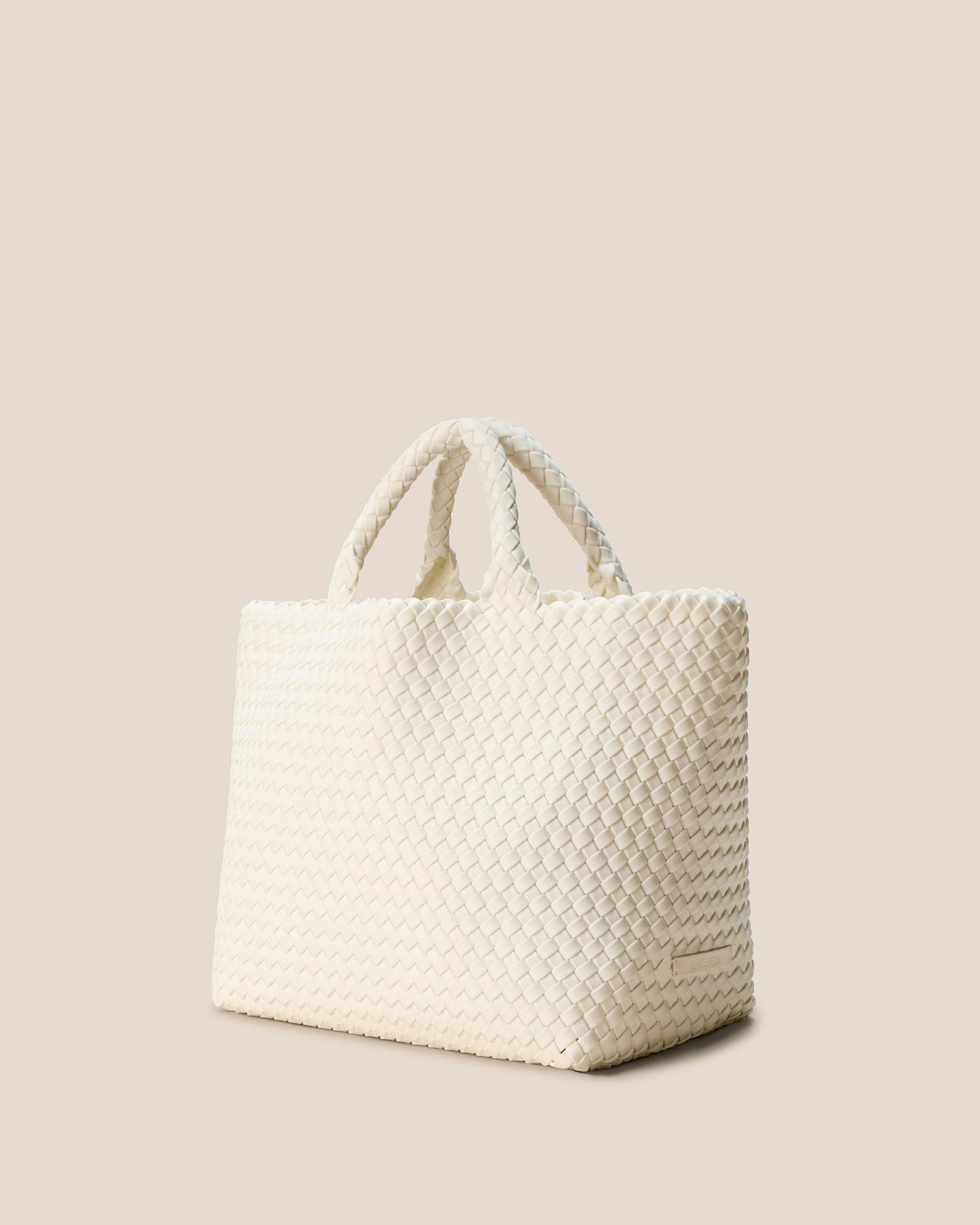 St. Barths Tote in Jasmine shown from a side angle, highlighting its handwoven neoprene construction and open top.