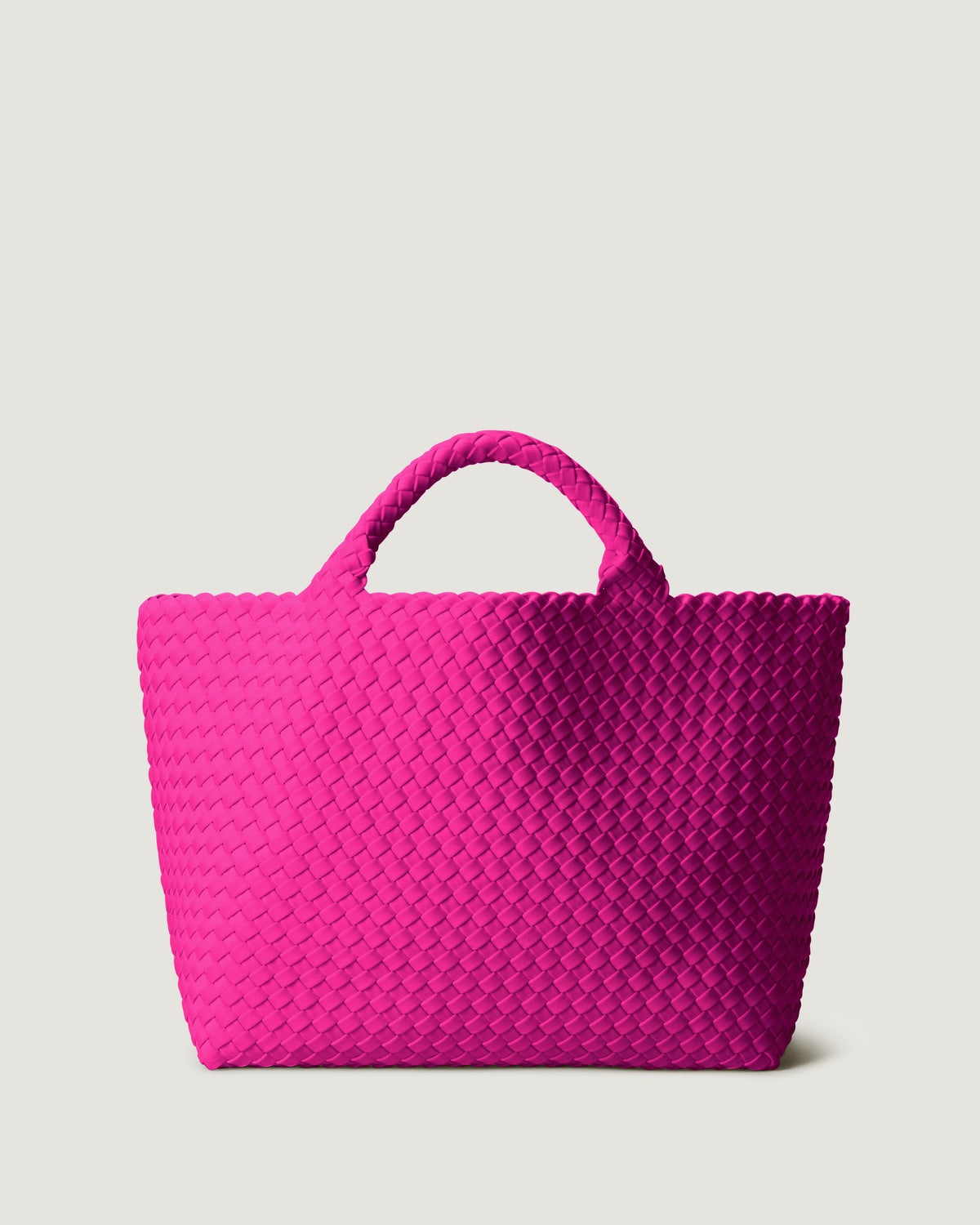 St. Barths Tote in Miami Pink in handwoven neoprene, featuring a magnetic closure, and woven top handles.