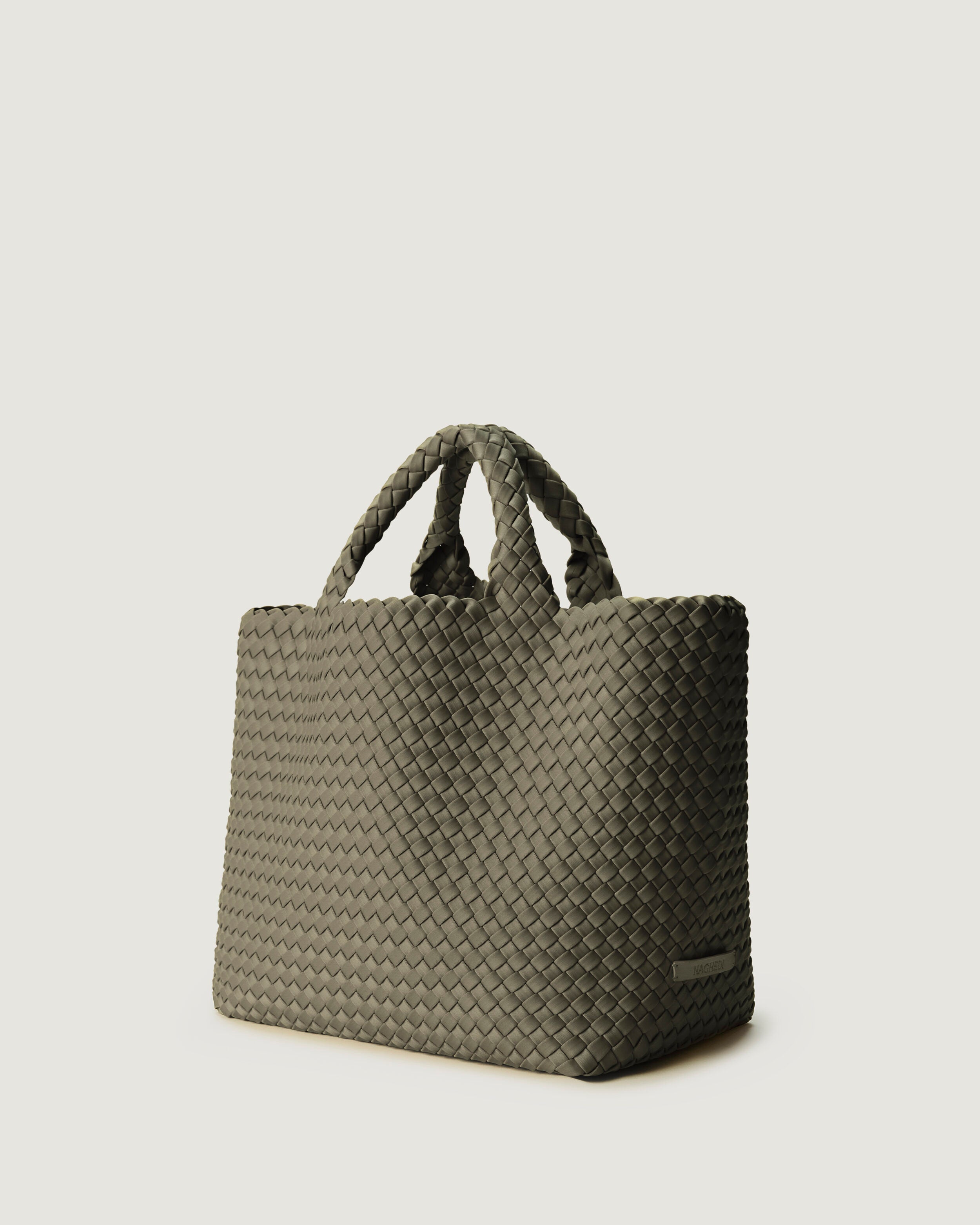 St. Barths Tote in Olea shown from a side angle, highlighting its handwoven neoprene construction and open top.