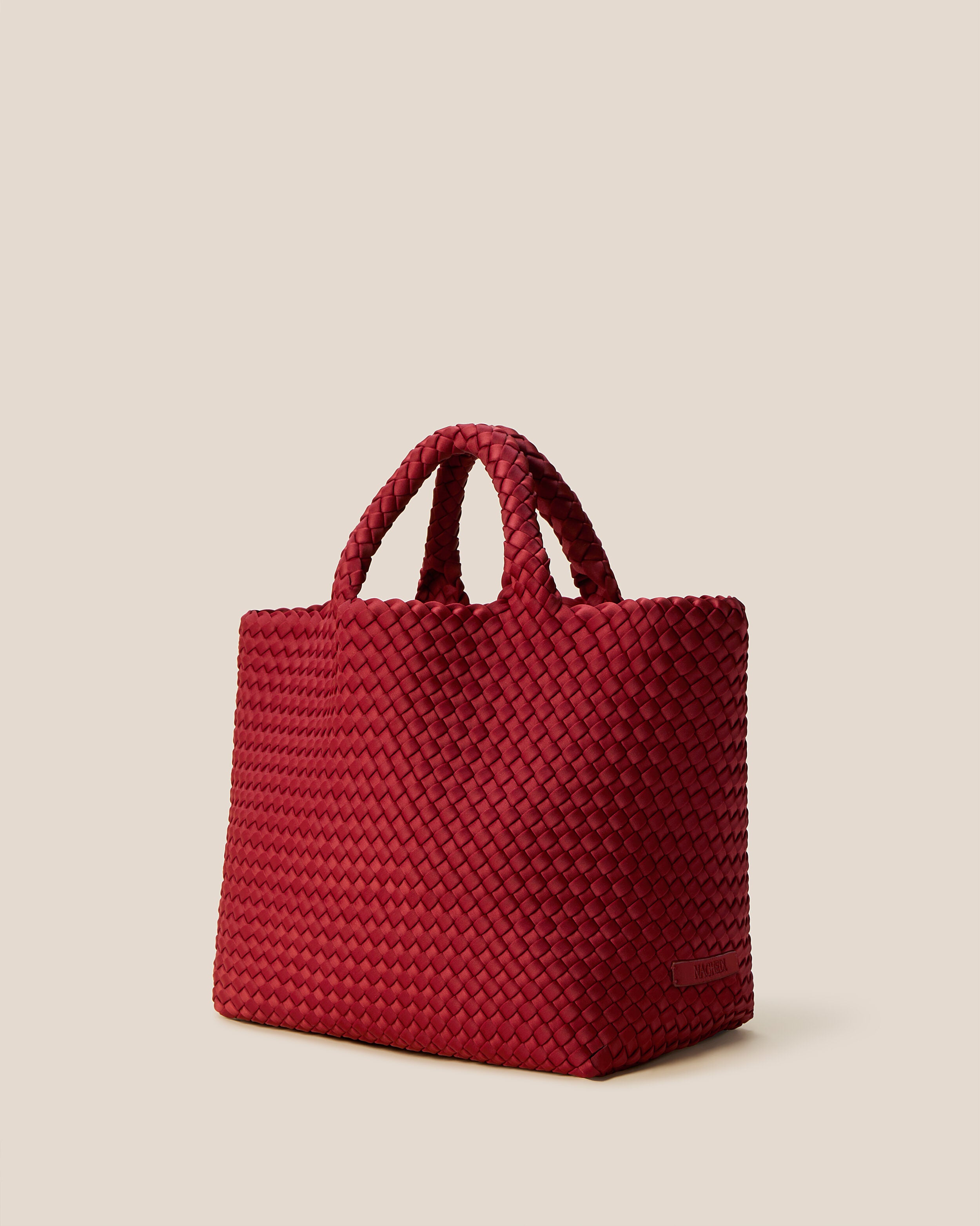 St. Barths Tote in Rosso shown from a side angle, highlighting its handwoven neoprene construction and open top.