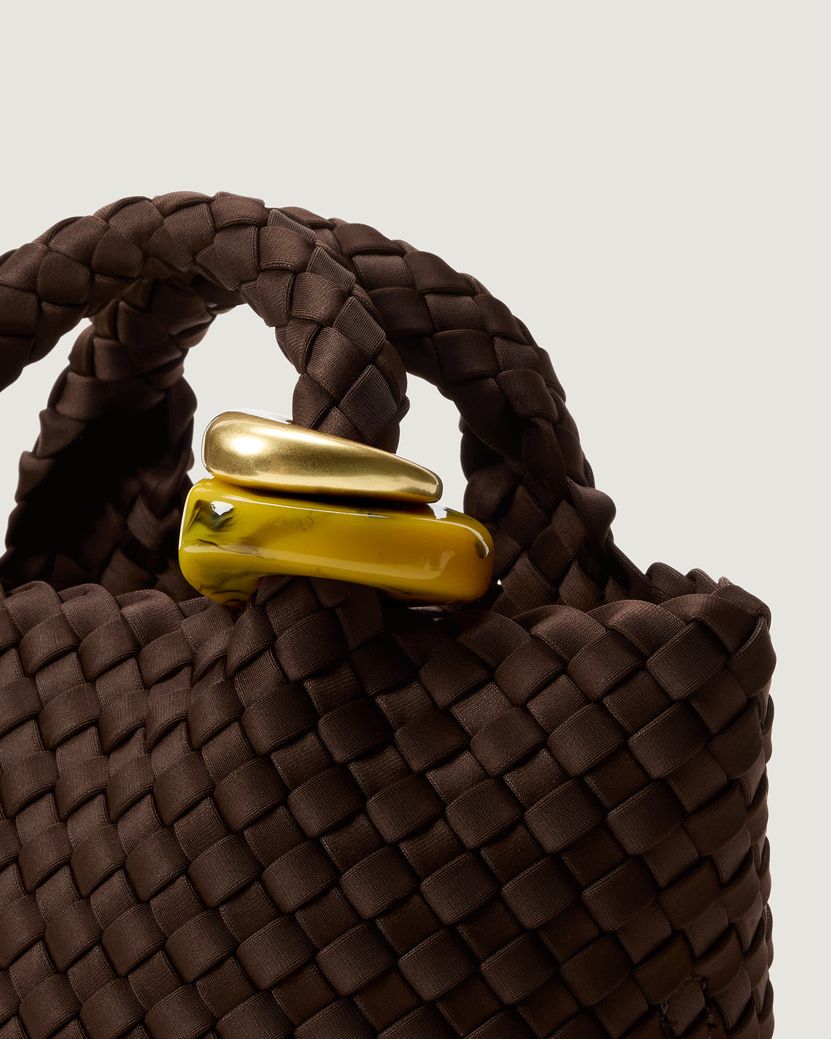 Close up of the St Barths Tote in Chocolate highlighting the two beads on the handle.