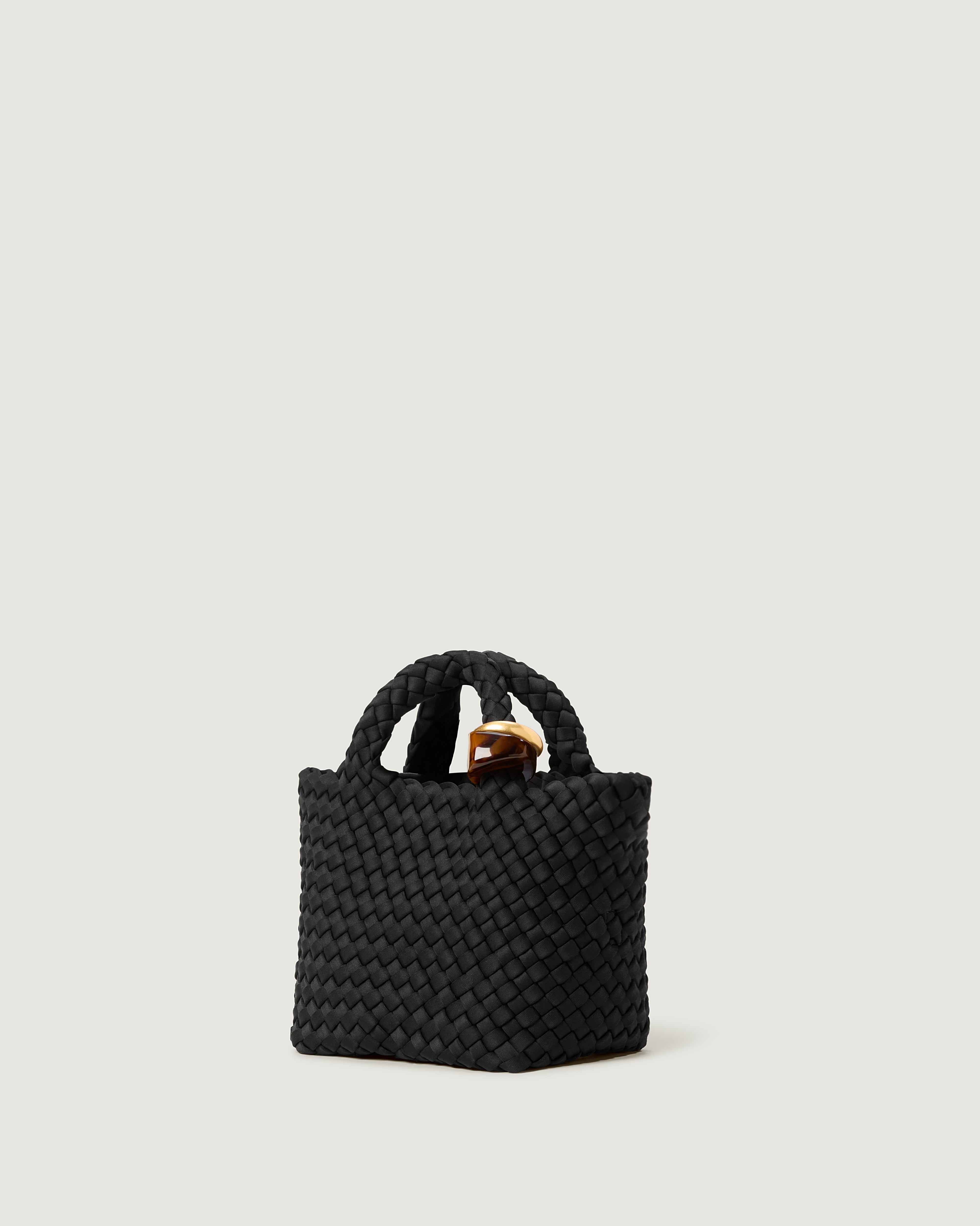 St. Barths Tote in Onyx shown from a side angle, highlighting its handwoven neoprene construction and open top.