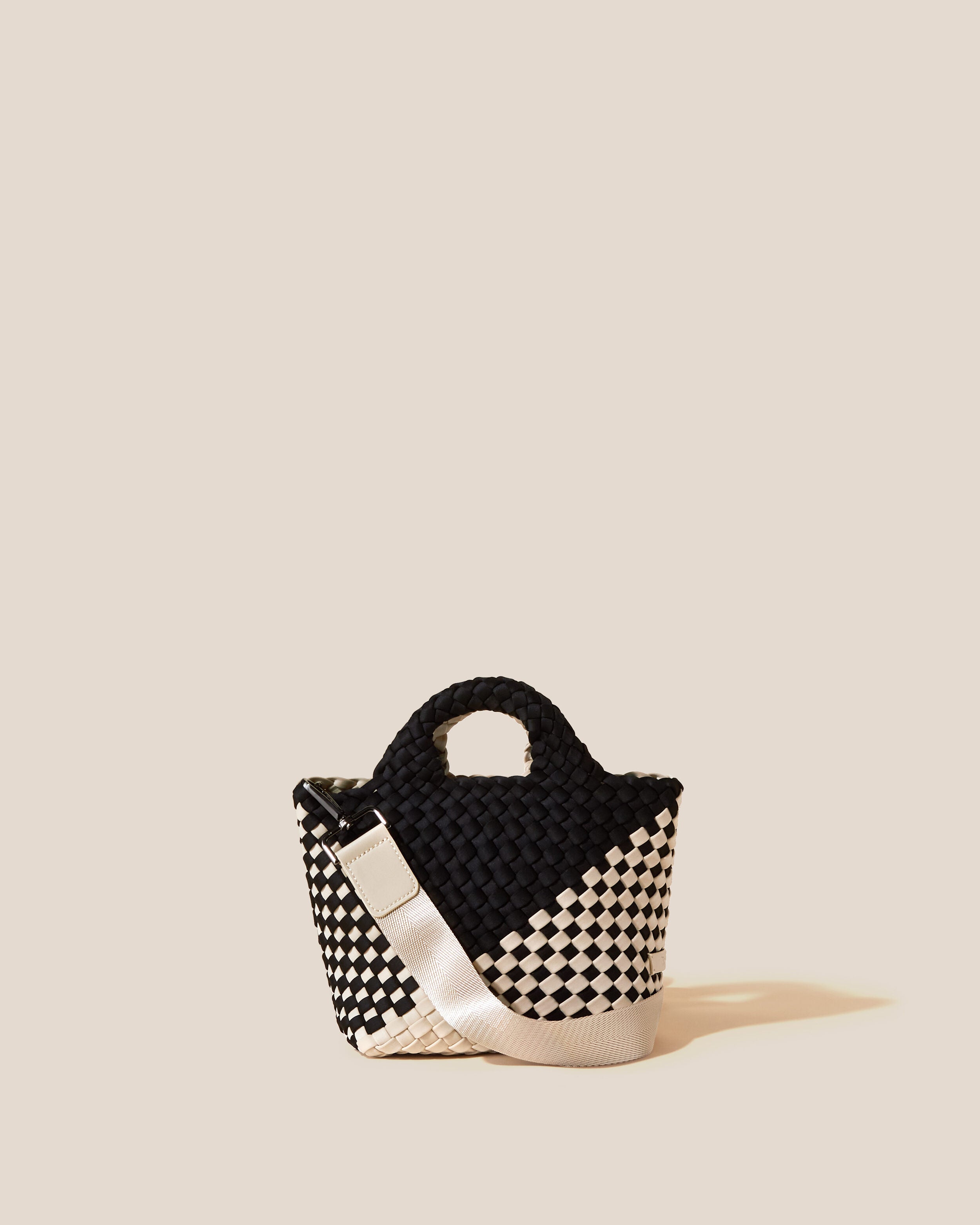 St. Barths Tote in Indio, a cream and true black tone, in handwoven neoprene, featuring an open top, woven top handles, and detachable, adjustable nylon crossbody strap.