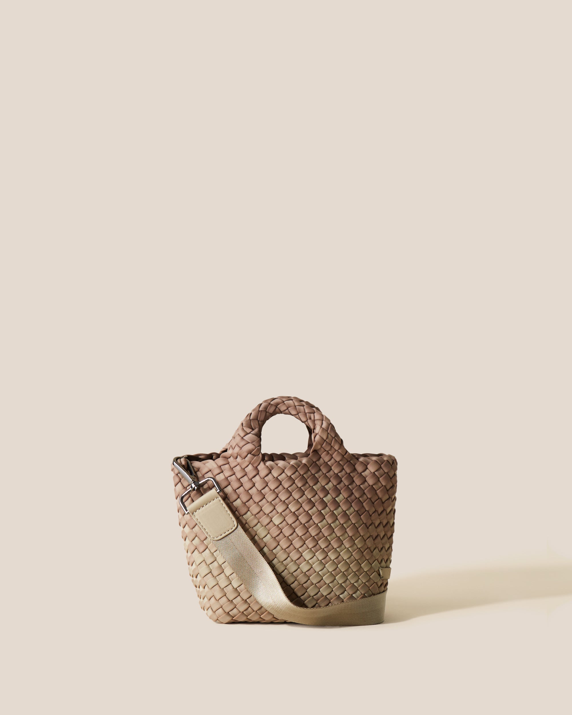 St. Barths Tote in Bronzed, a shades of beige tone, in handwoven neoprene, featuring an open top, woven top handles, and detachable, adjustable nylon crossbody strap.