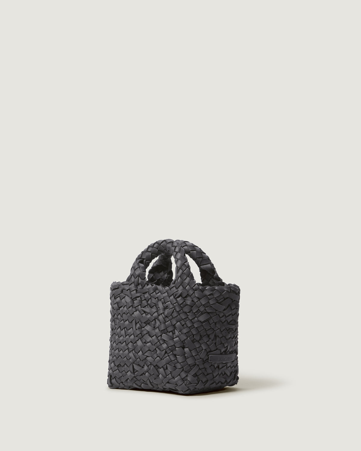 A cool taupe woven basket-style neoprene handbag with a top handle.