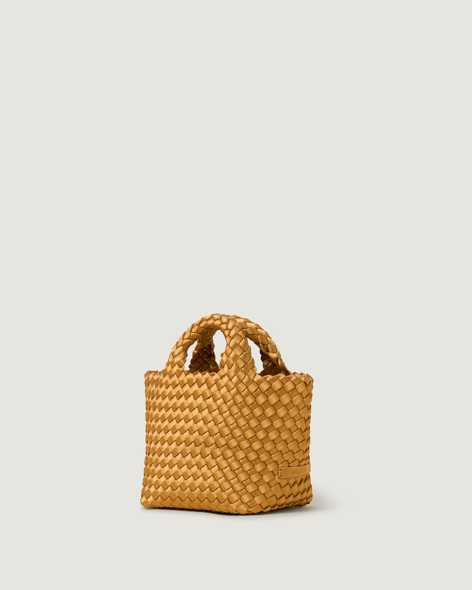 St. Barths Petit Satin Tote Bag in Ore shown from a side angle, highlighting its handwoven neoprene and open top.