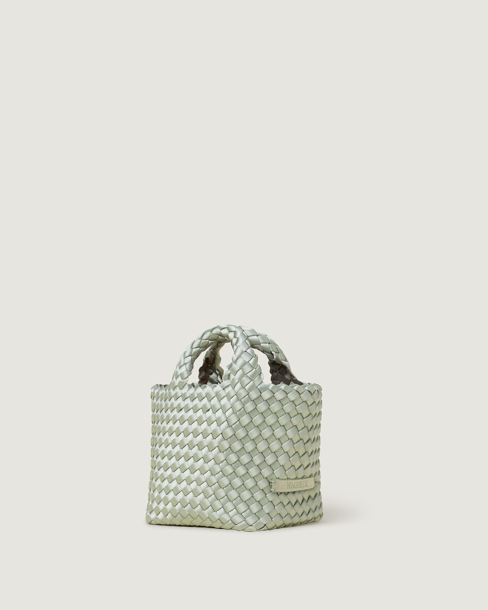 St. Barths Petit Satin Tote Bag in Wintergreen shown from a side angle, highlighting its handwoven neoprene and open top.