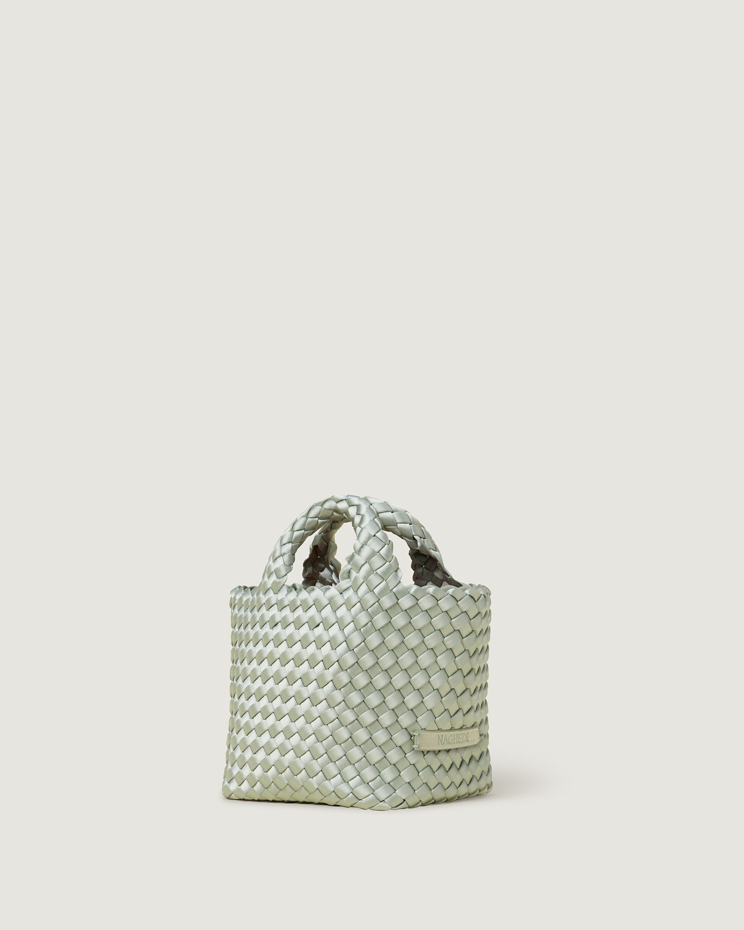St. Barths Tote in Wintergreen shown from a side angle, highlighting its handwoven neoprene construction and open top.