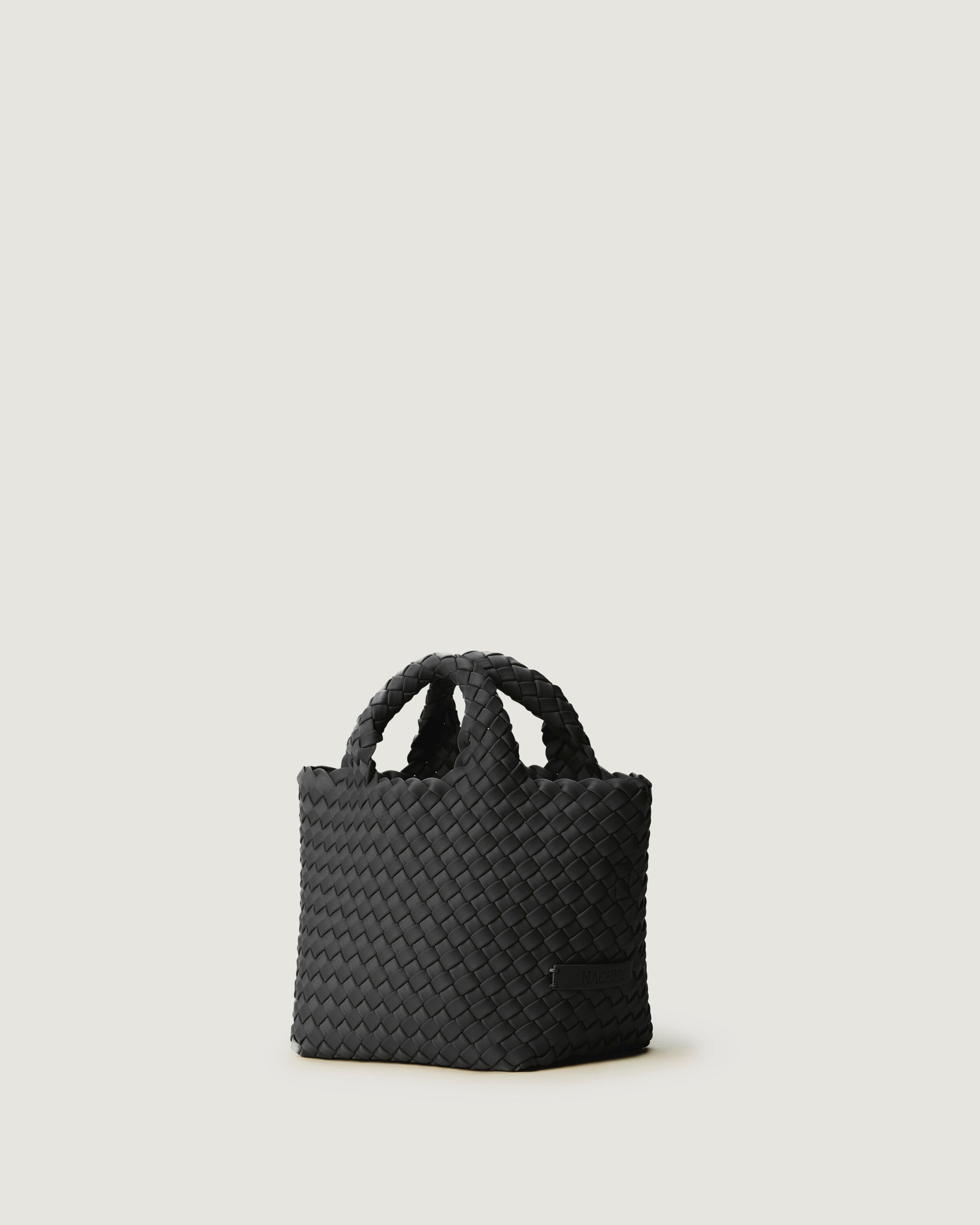 St. Barths Tote in Ash shown from a side angle, highlighting its handwoven neoprene construction and open top.