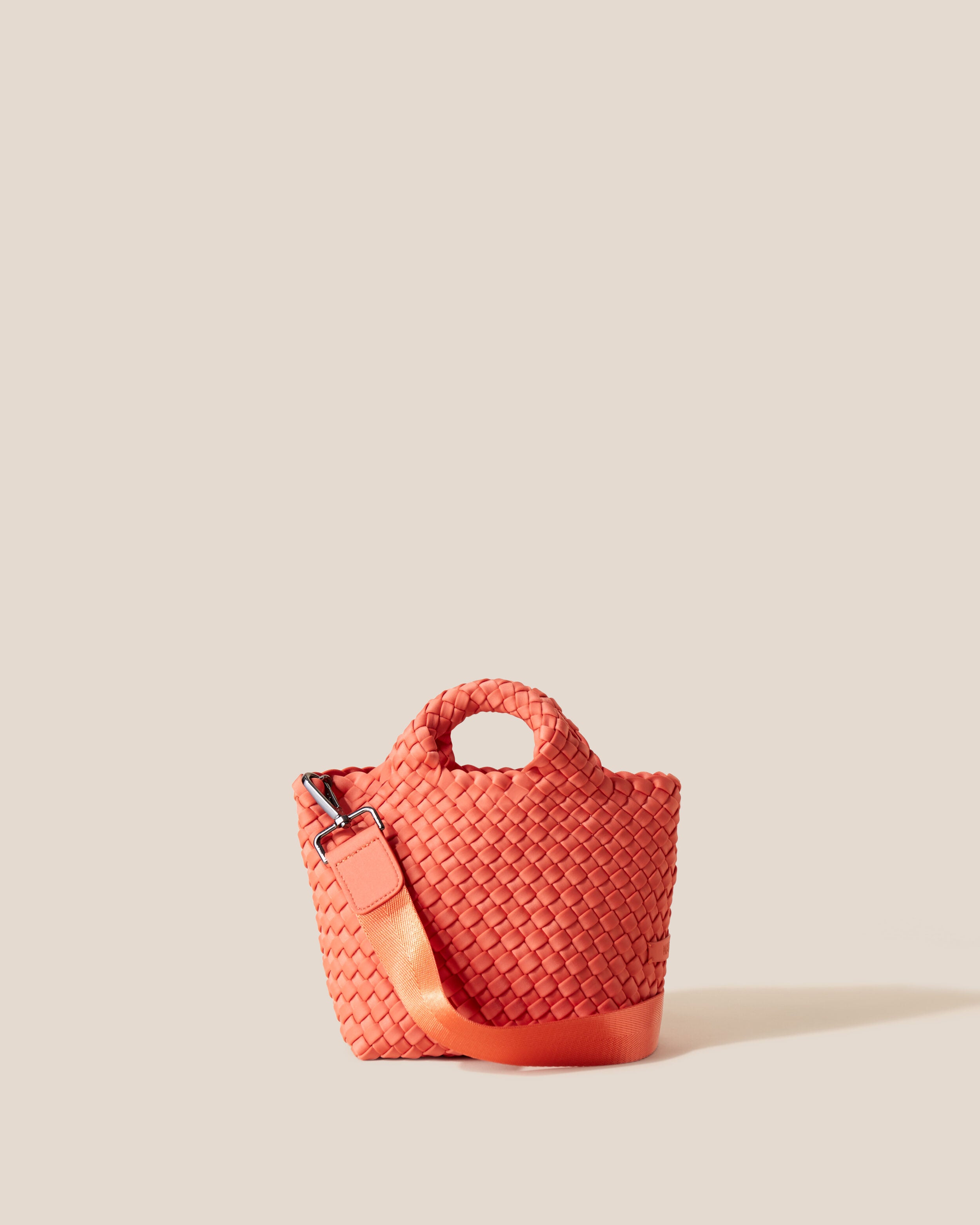 St. Barths Tote in Bonaire, a muted orange tone, in handwoven neoprene, featuring an open top, woven top handles, and detachable, adjustable nylon crossbody strap.