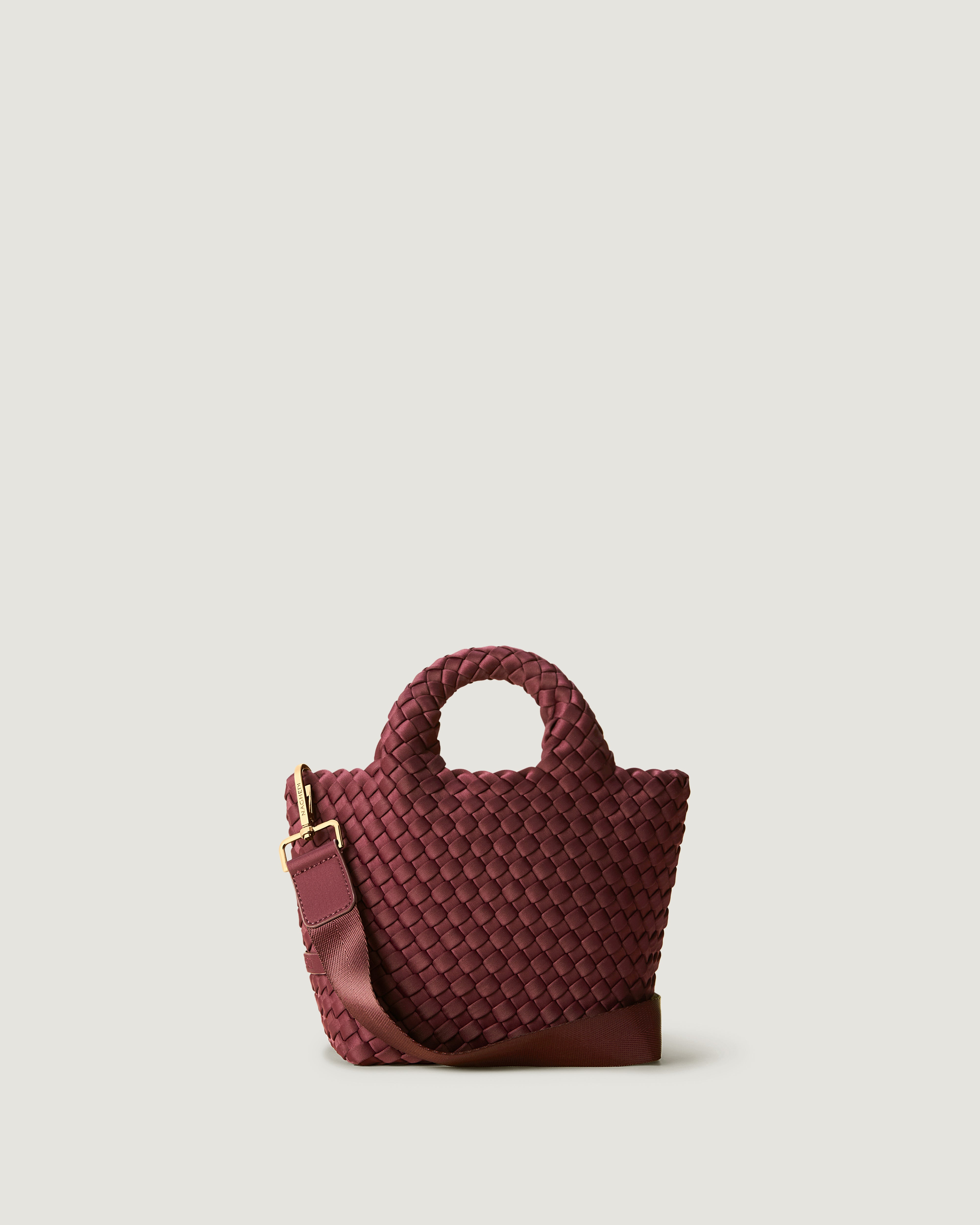 St. Barths Tote in Bordeaux, a burgundy  tone, in handwoven neoprene, featuring an open top, woven top handles, and detachable, adjustable nylon crossbody strap.