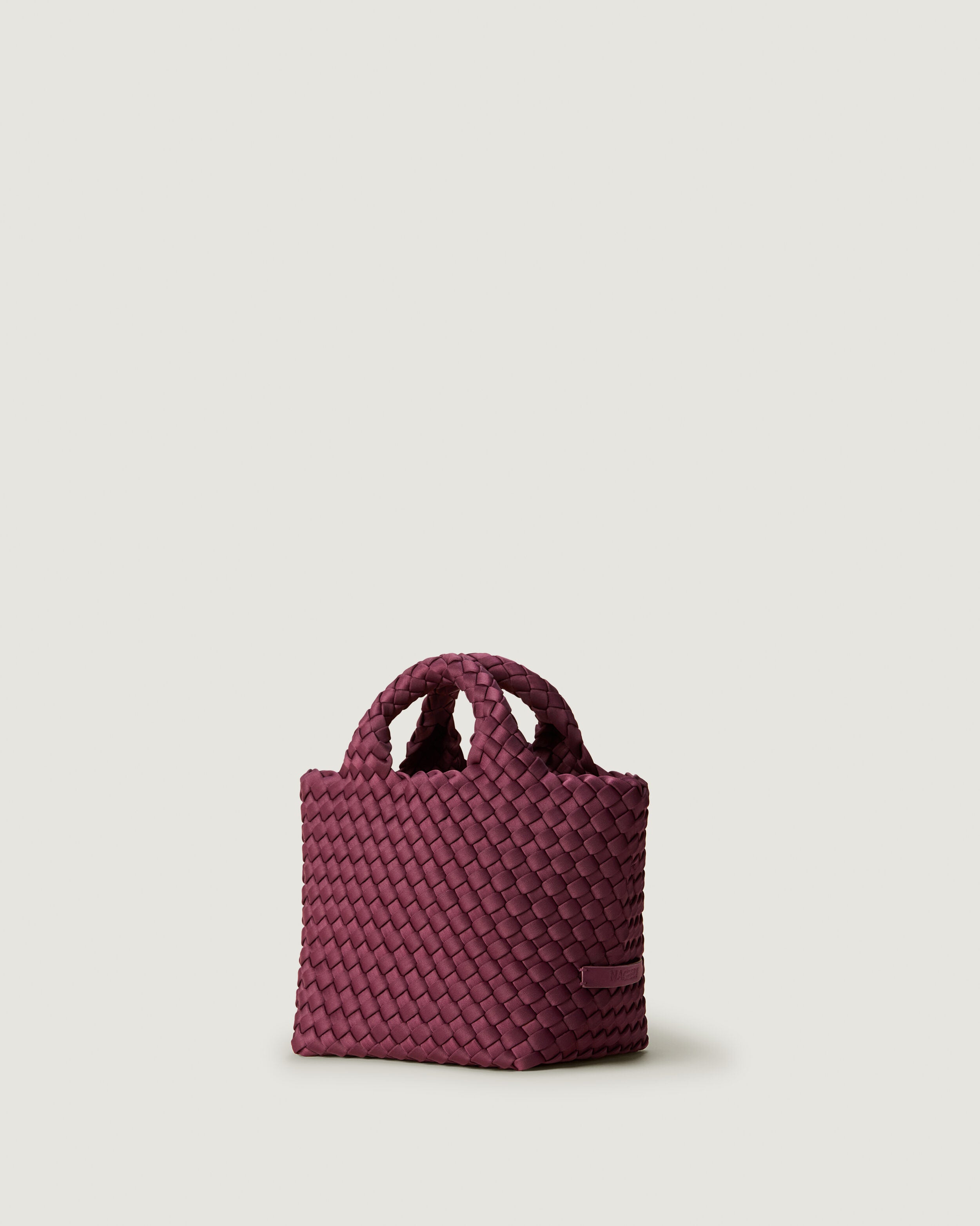 St. Barths Tote in Bordeaux shown from a side angle, highlighting its handwoven neoprene construction and open top.