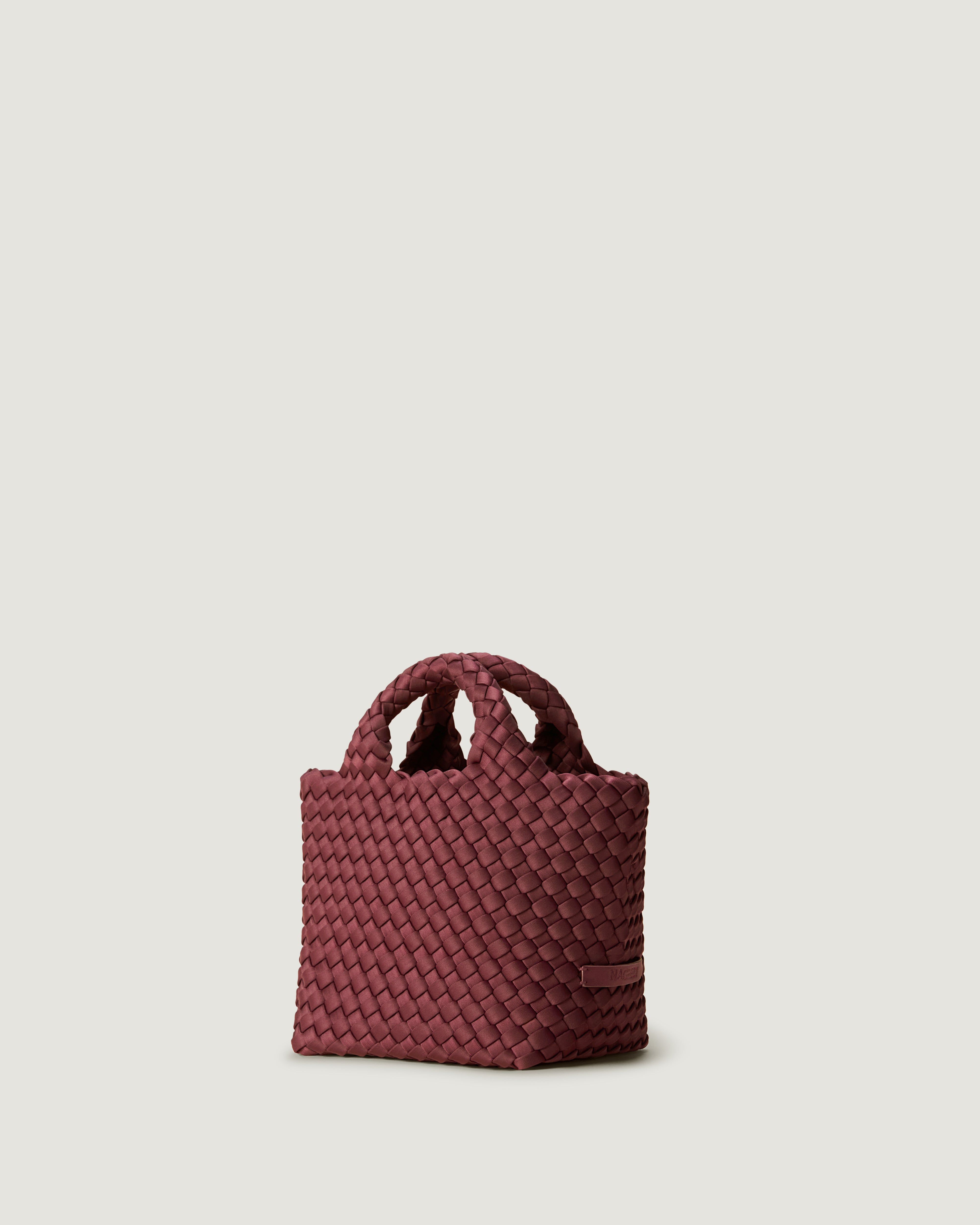 St. Barths Tote in Bordeaux shown from a side angle, highlighting its handwoven neoprene construction and open top.