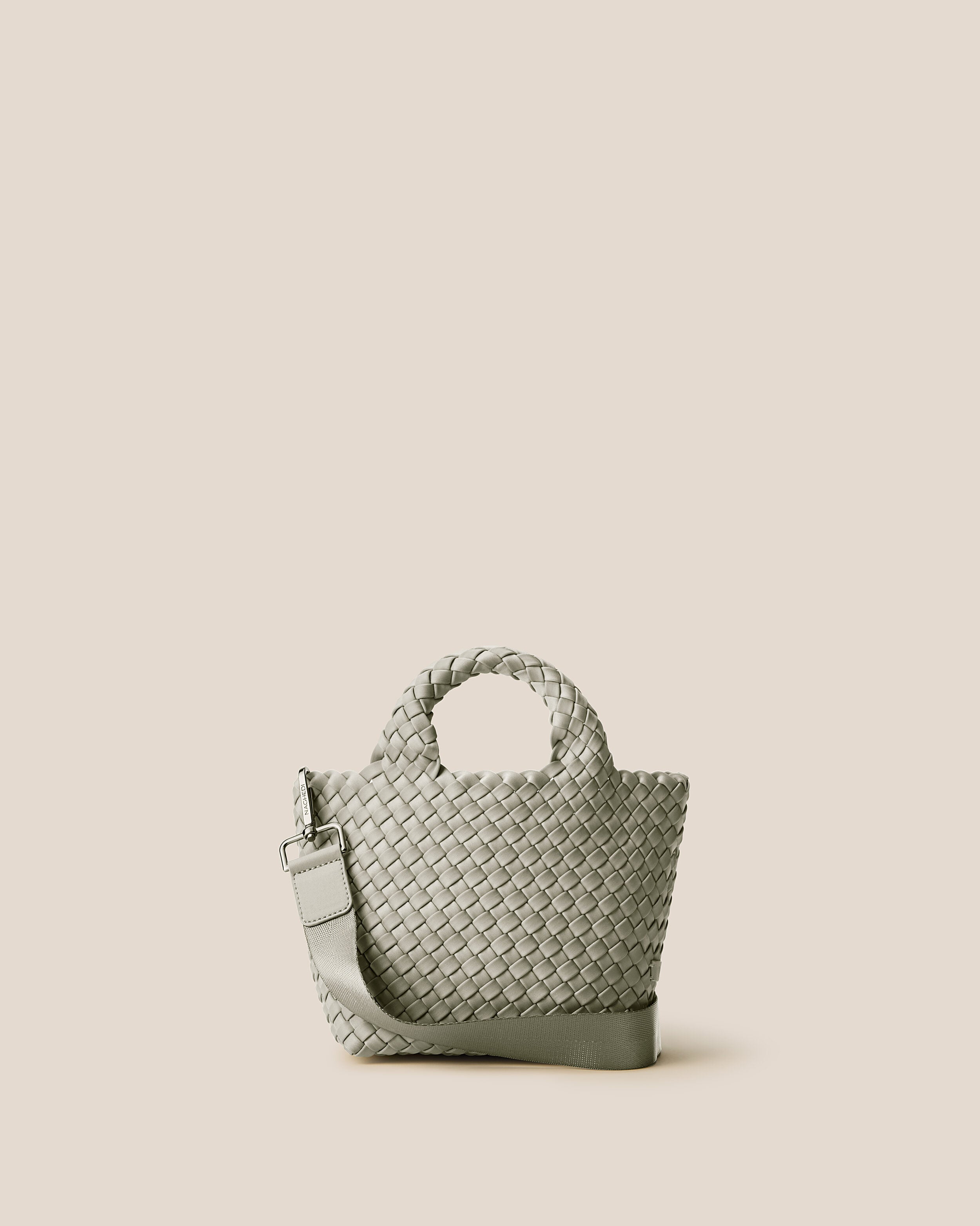 St. Barths Tote in Celadon, a light jade green tone, in handwoven neoprene, featuring an open top, woven top handles, and detachable, adjustable nylon crossbody strap.