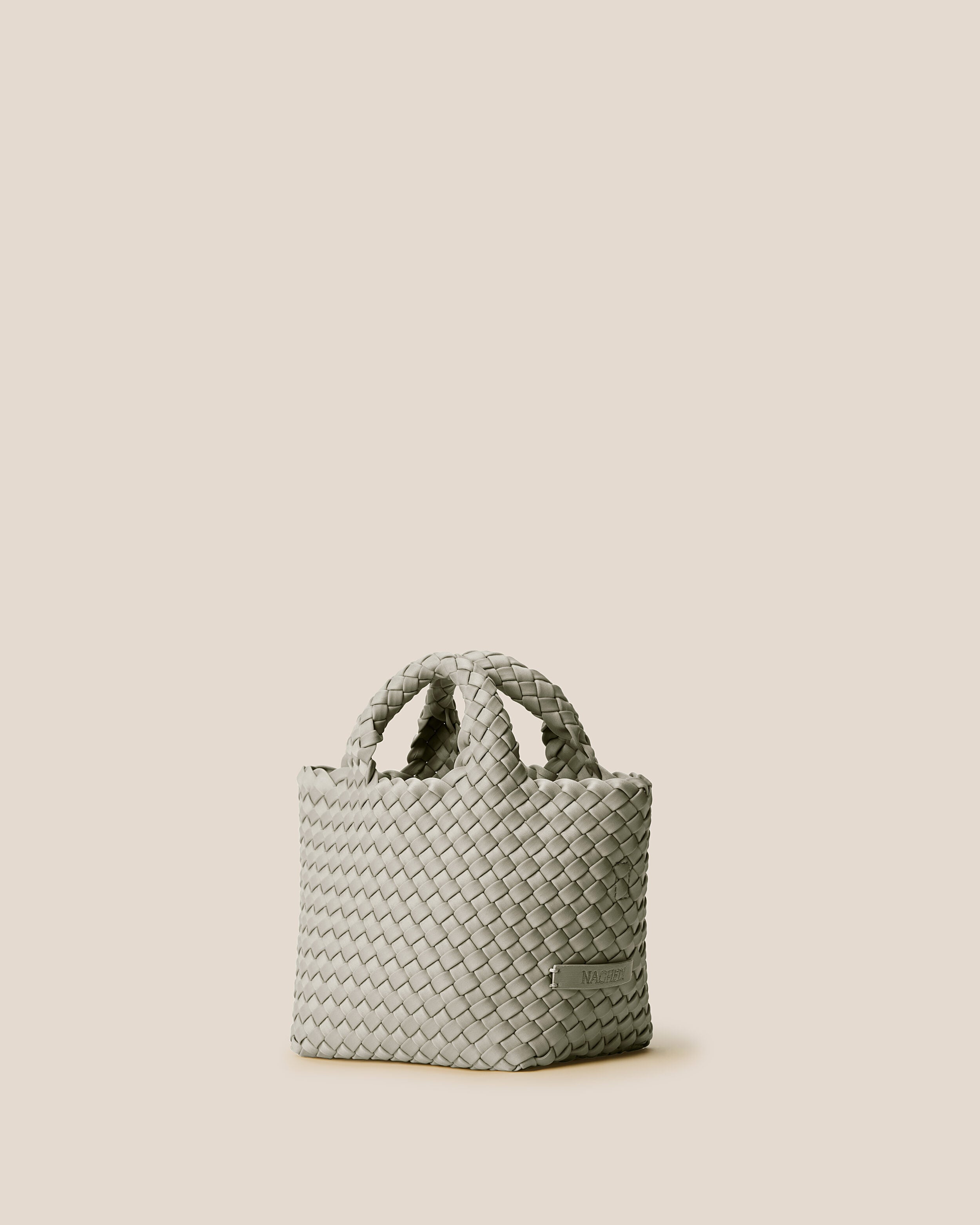 St. Barths Tote in Celadon shown from a side angle, highlighting its handwoven neoprene construction and open top.