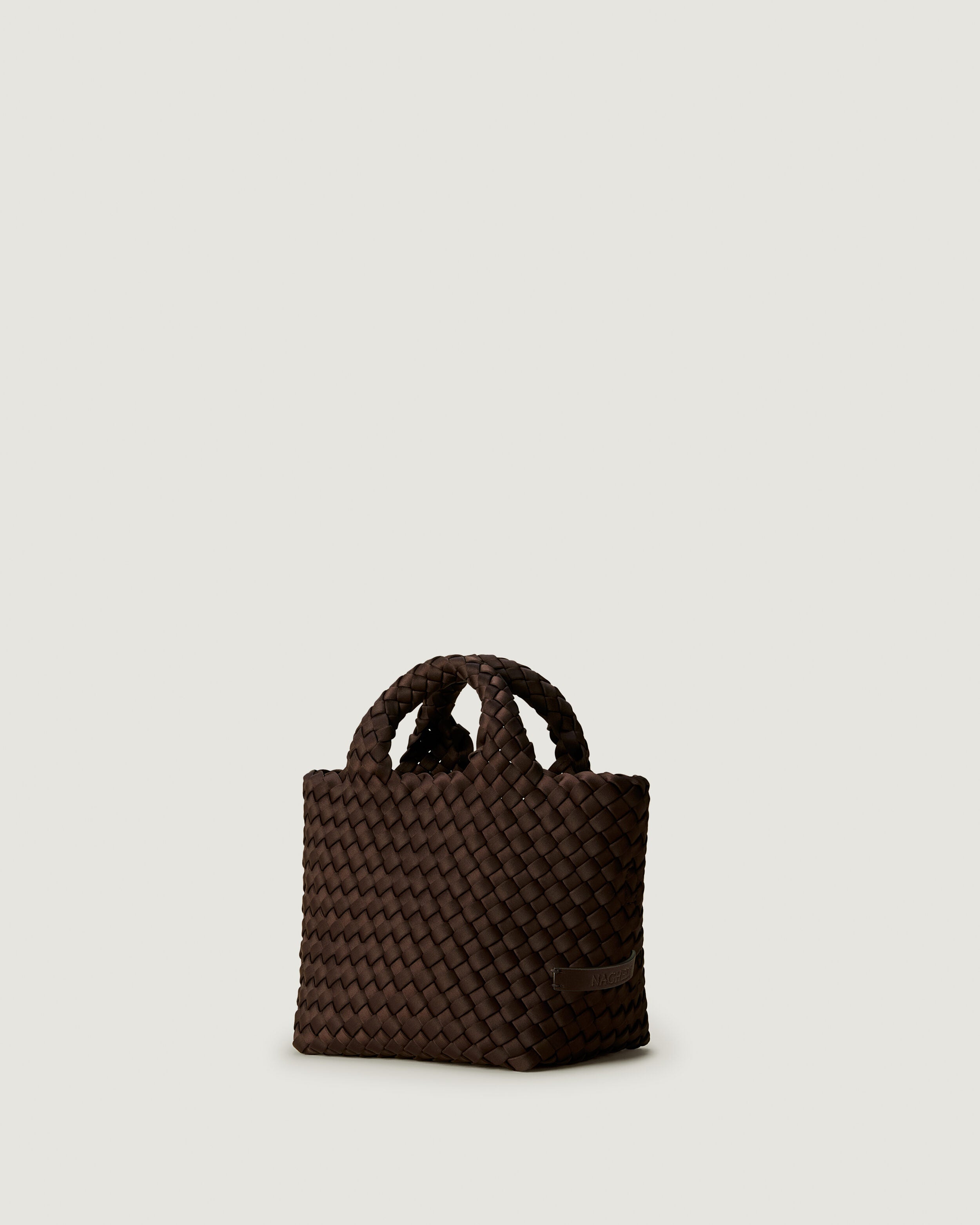 St. Barths Tote in Chocolate shown from a side angle, highlighting its handwoven neoprene construction and open top.