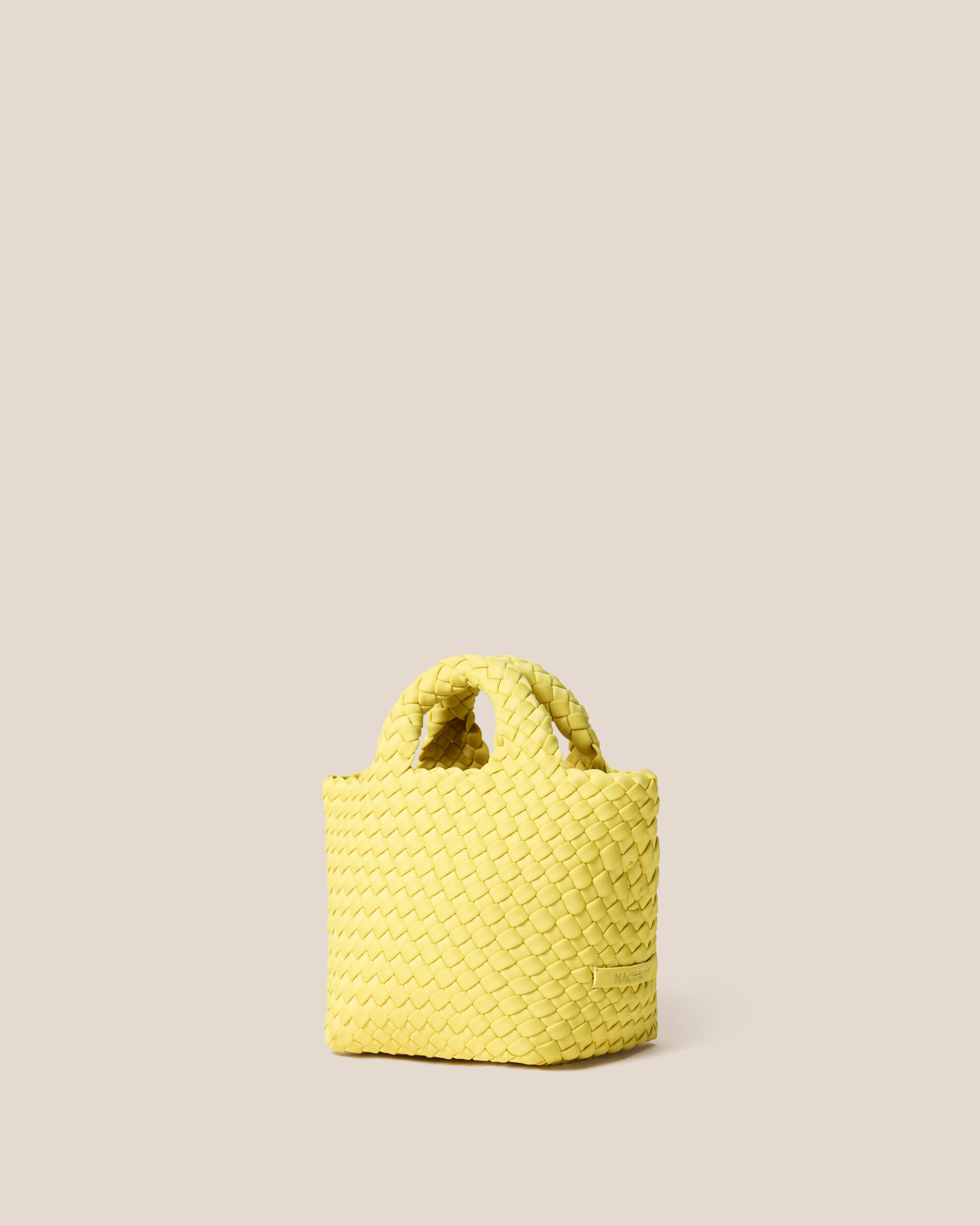 St. Barths Tote in Citron shown from a side angle, highlighting its handwoven neoprene construction and open top.