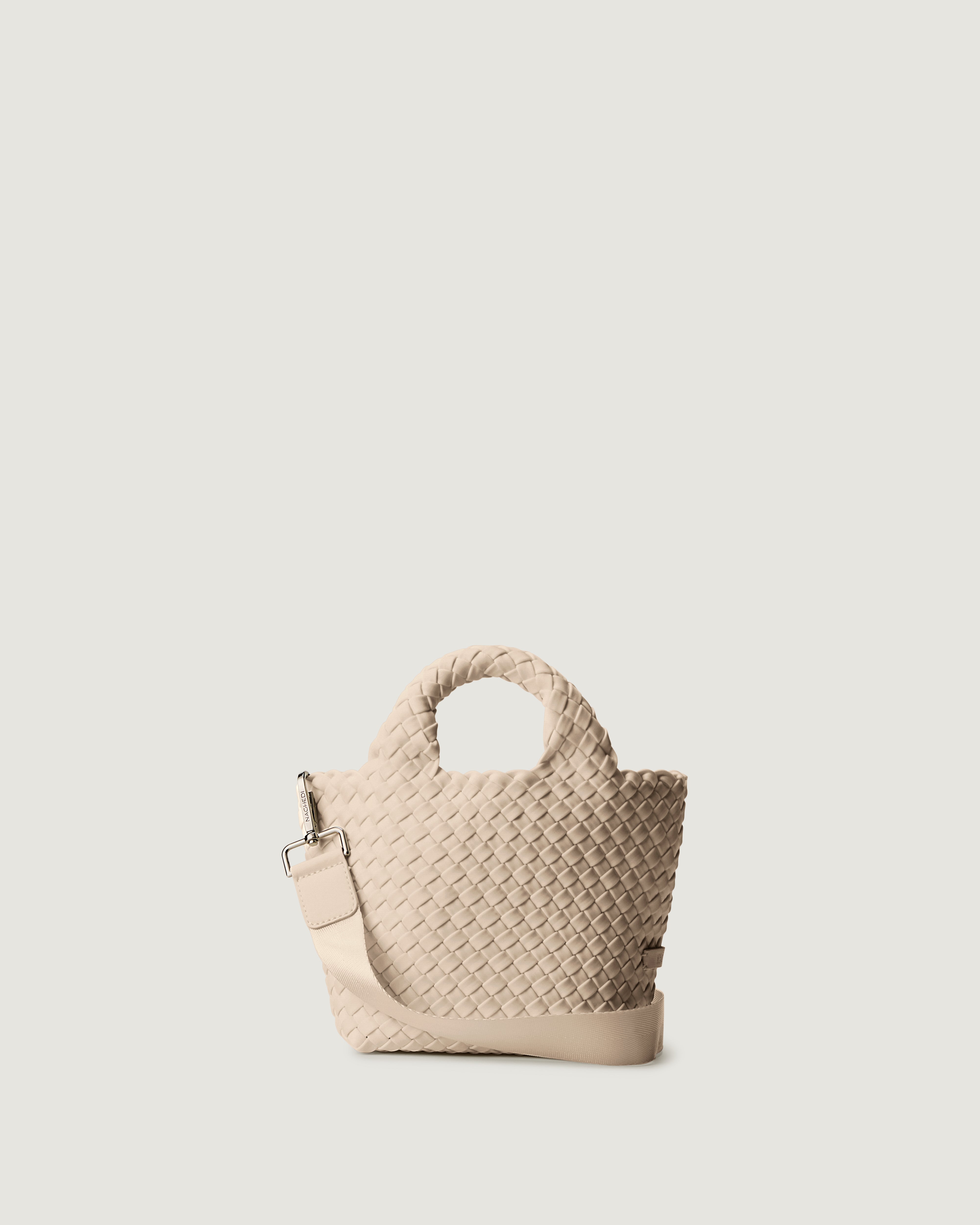 St. Barths Tote in Ecru, a cream tone, in handwoven neoprene, featuring an open top, woven top handles, and detachable, adjustable nylon crossbody strap.