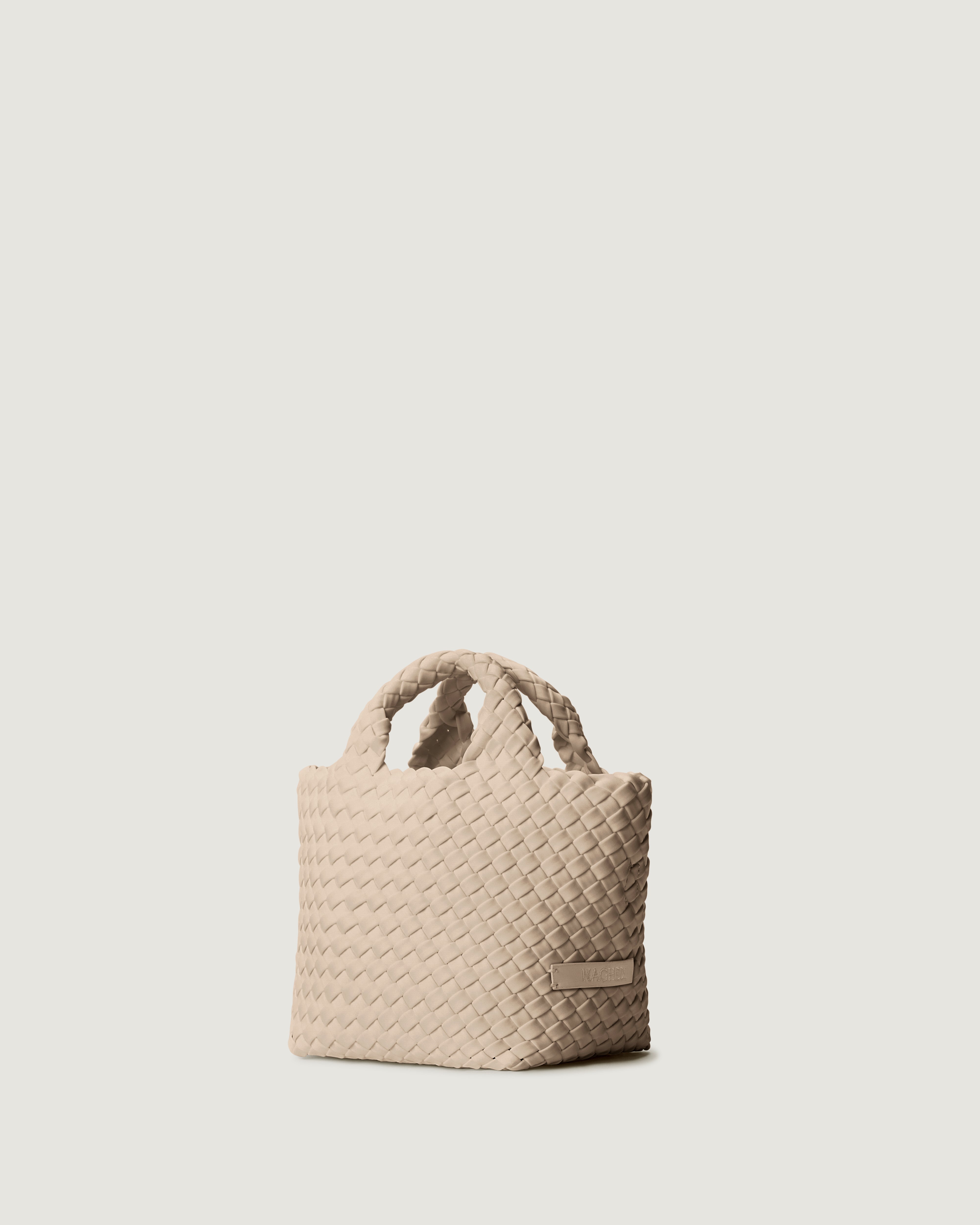 St. Barths Tote in Ecru shown from a side angle, highlighting its handwoven neoprene construction and open top.