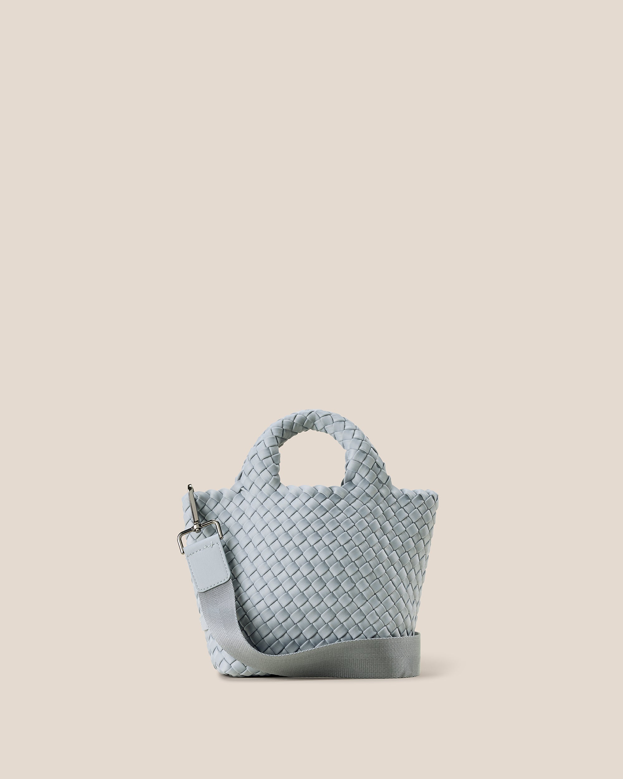 St. Barths Tote in Glacier, an ice blue tone, in handwoven neoprene, featuring an open top, woven top handles, and detachable, adjustable nylon crossbody strap.