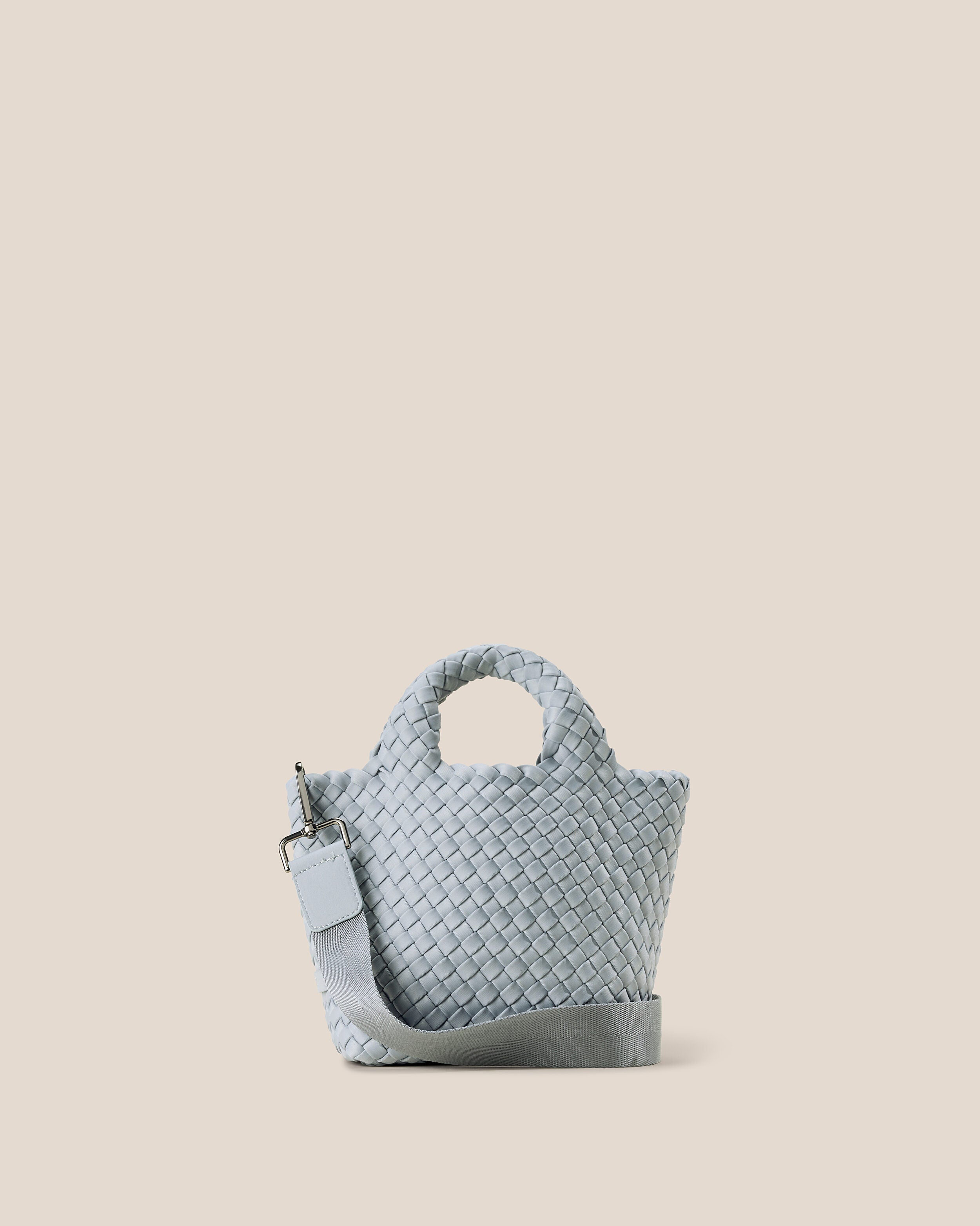 St. Barths Tote in Glacier, an ice blue tone, in handwoven neoprene, featuring an open top, woven top handles, and detachable, adjustable nylon crossbody strap.