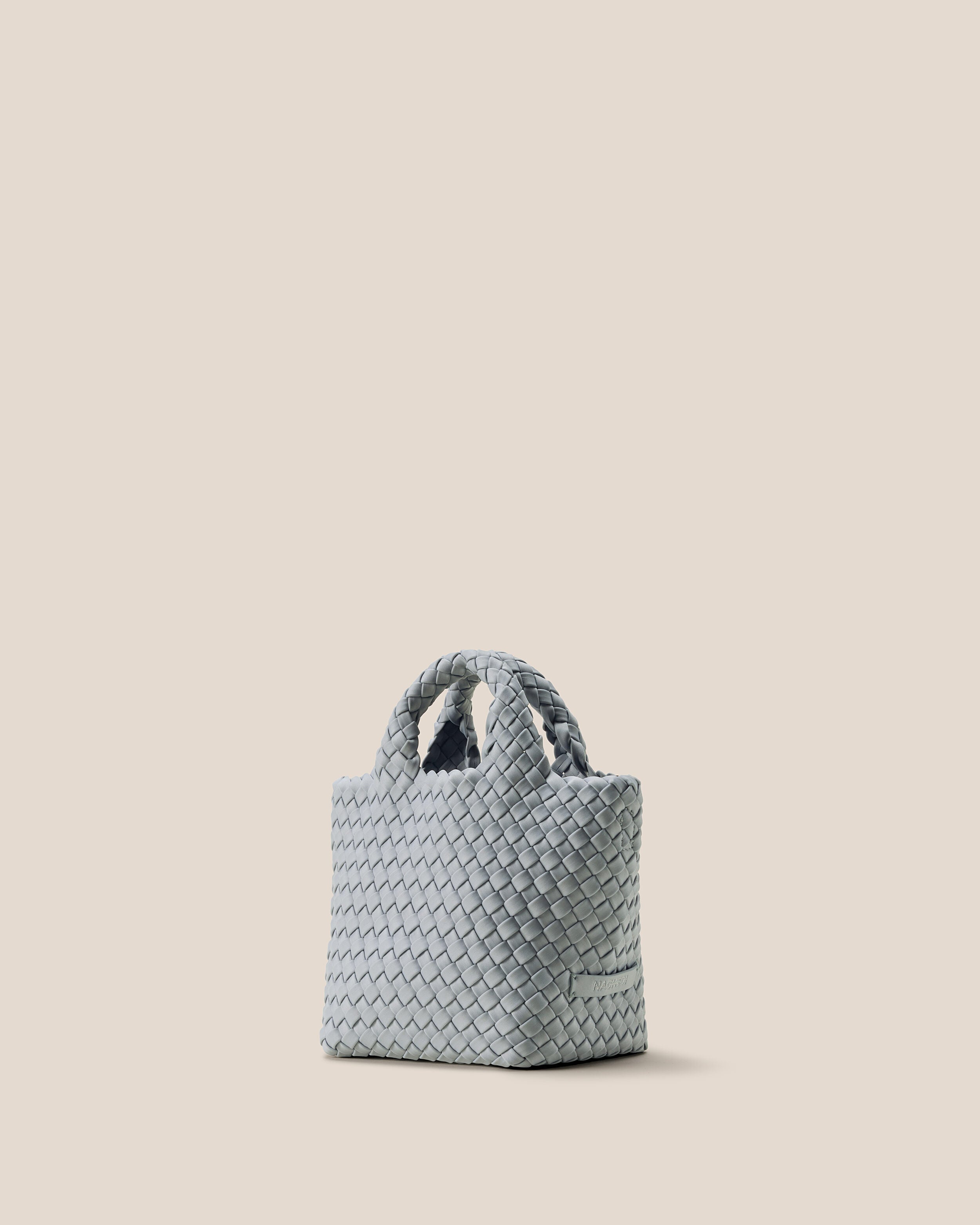 St. Barths Tote in Glacier shown from a side angle, highlighting its handwoven neoprene construction and open top.