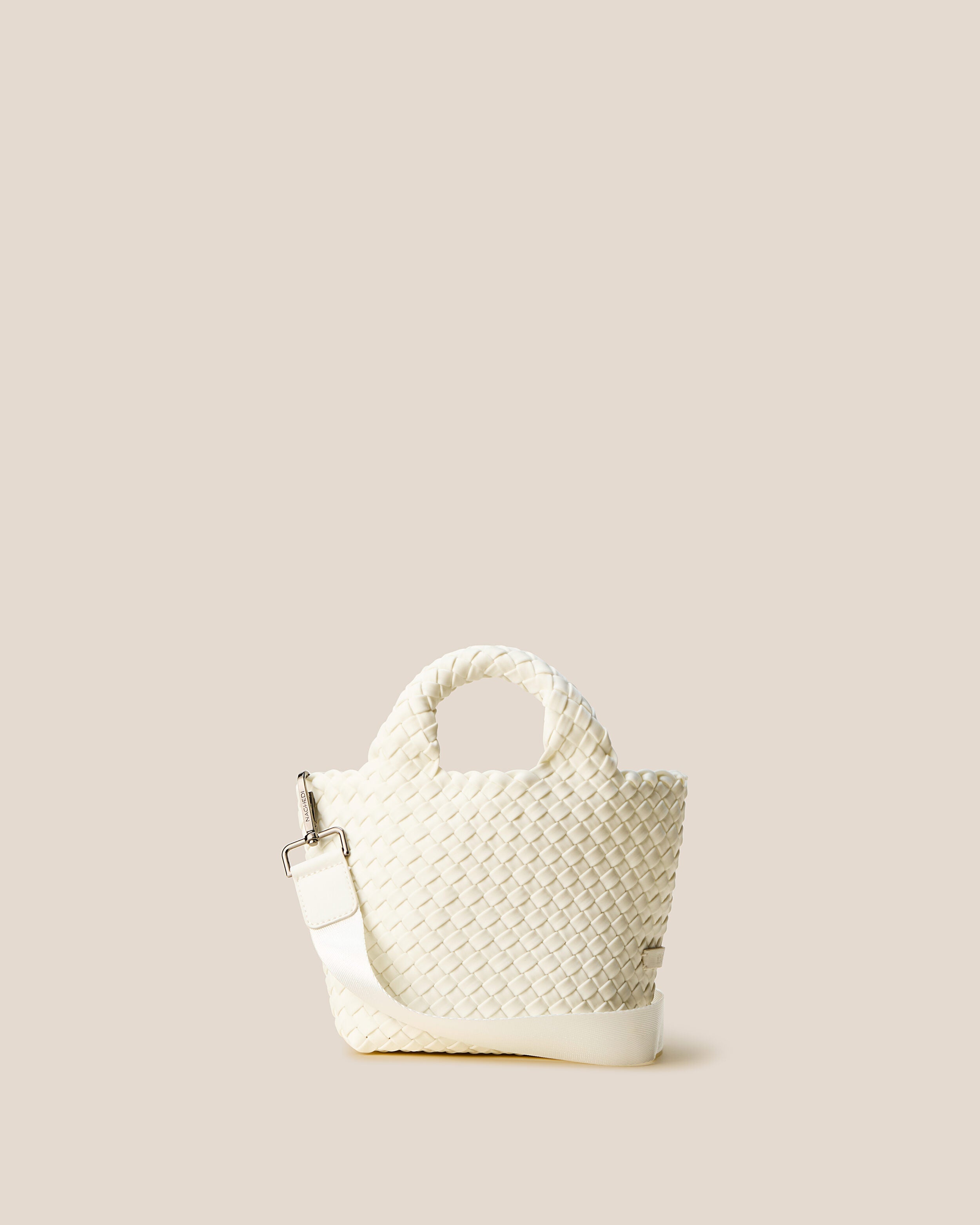 St. Barths Tote in Jasmine, an ivory tone, in handwoven neoprene, featuring an open top, woven top handles, and detachable, adjustable nylon crossbody strap.