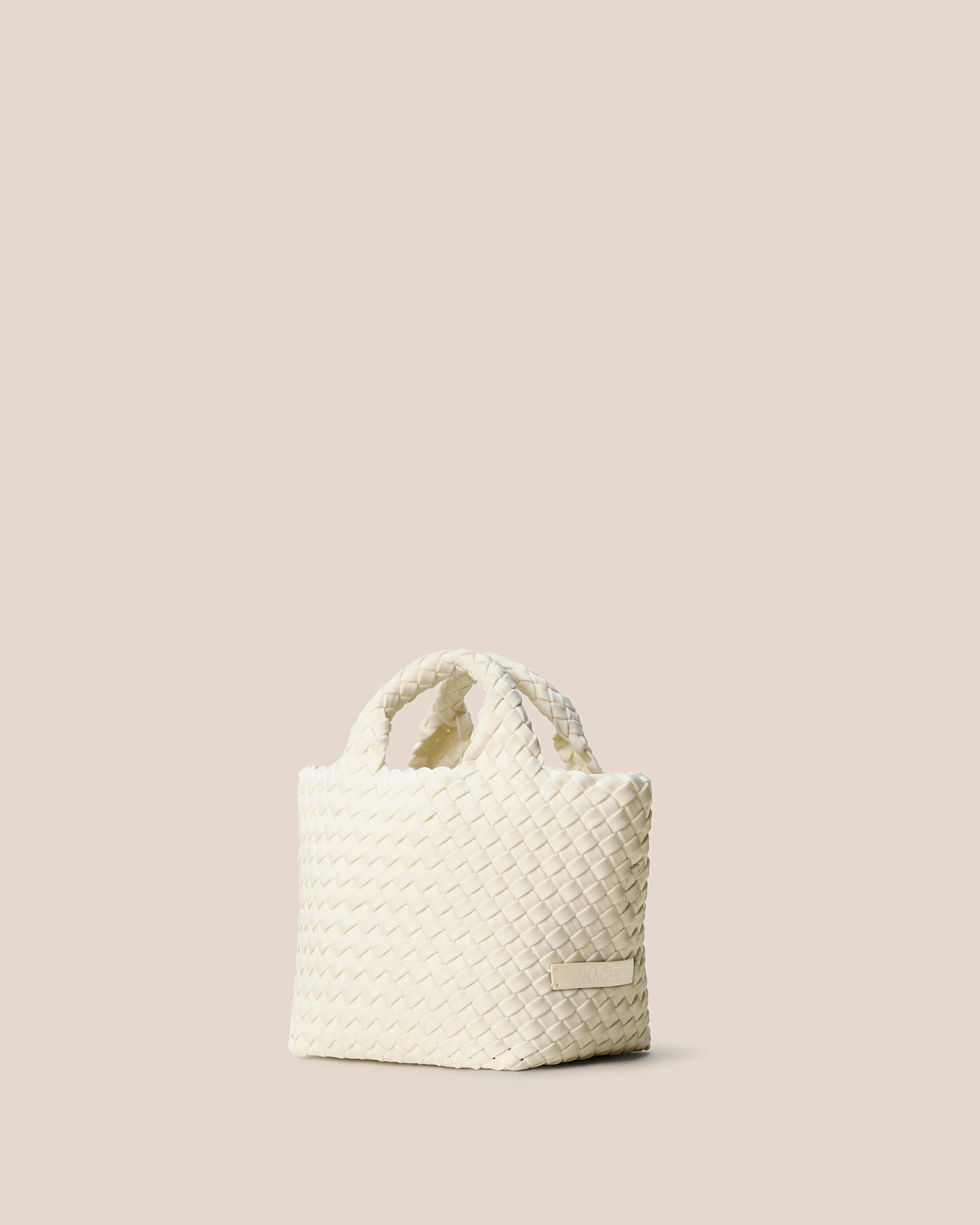 St. Barths Tote in Jasmine shown from a side angle, highlighting its handwoven neoprene construction and open top.