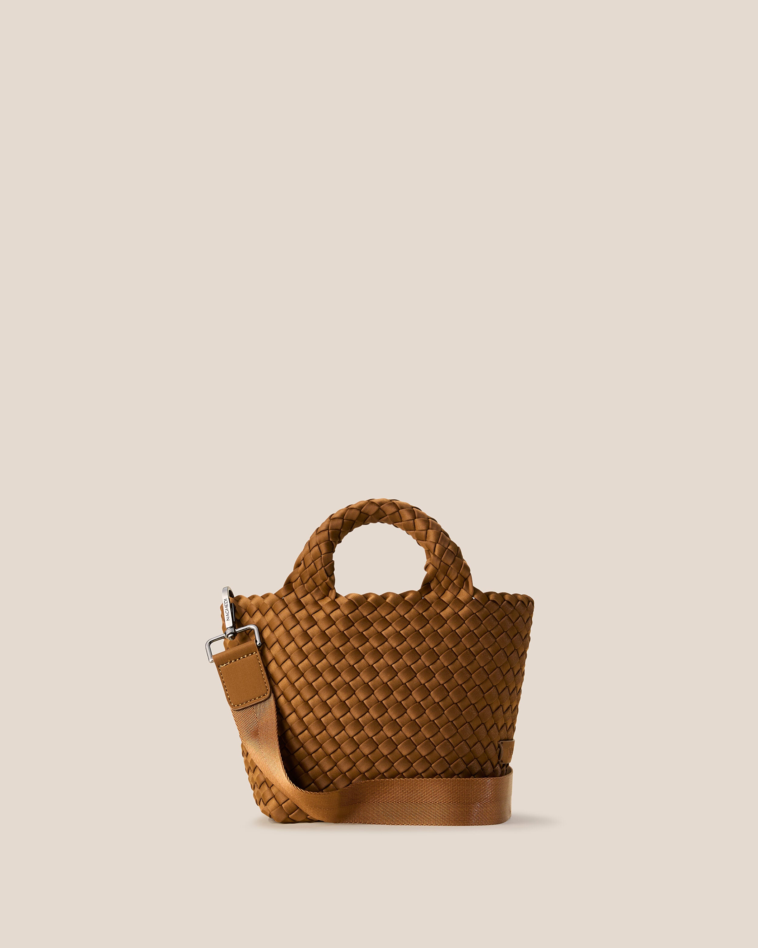 St. Barths Tote in Teak, a saddle brown tone, in handwoven neoprene, featuring an open top, woven top handles, and detachable, adjustable nylon crossbody strap.