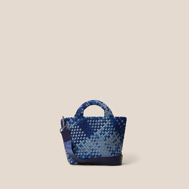 St. Barths Tote in Paros, a denim blue and navy tone, in handwoven neoprene, featuring an open top, woven top handles, and detachable, adjustable nylon crossbody strap.