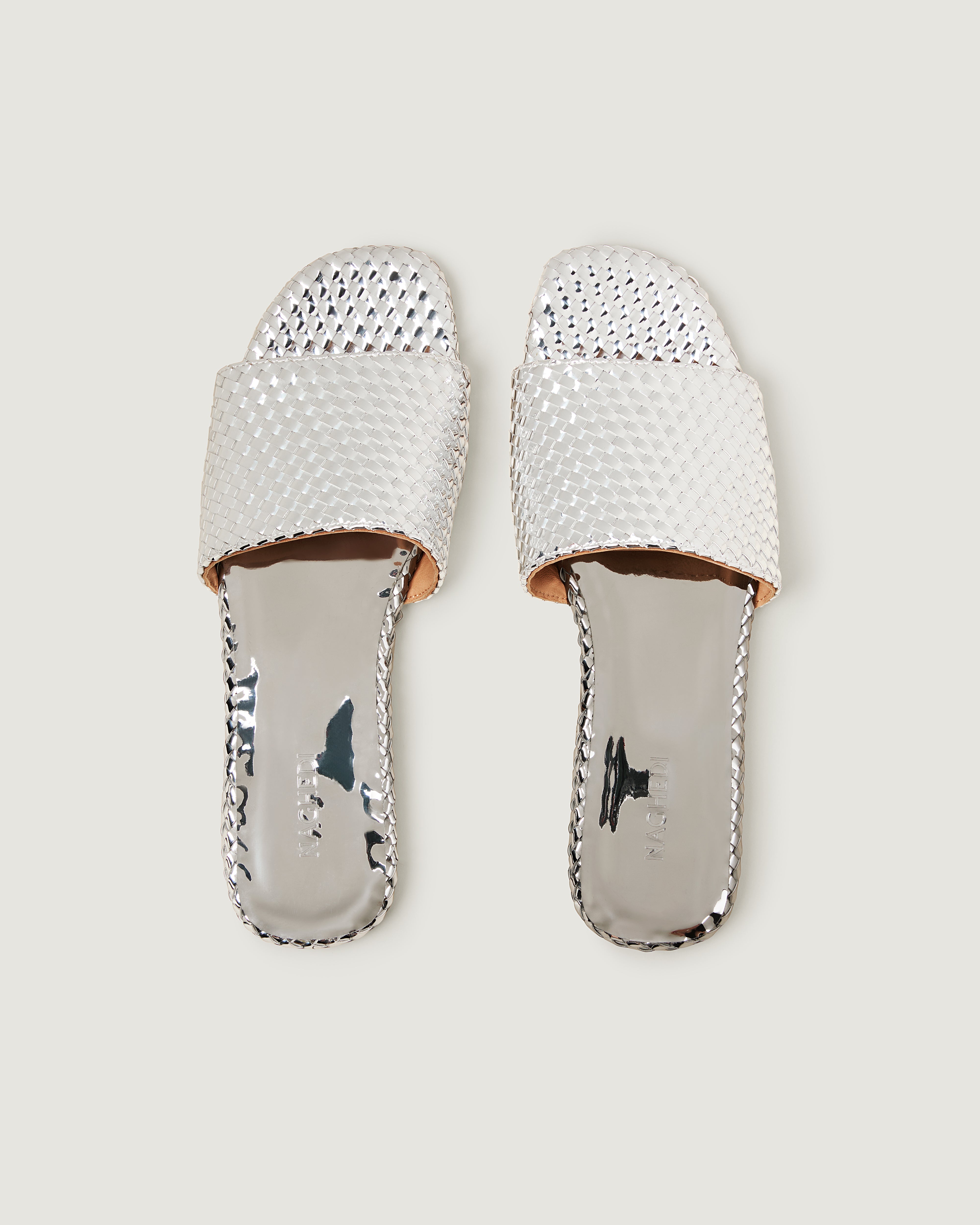 Top view of pair of The St. Barths Slide in Silver showing the handwoven metallic insole.