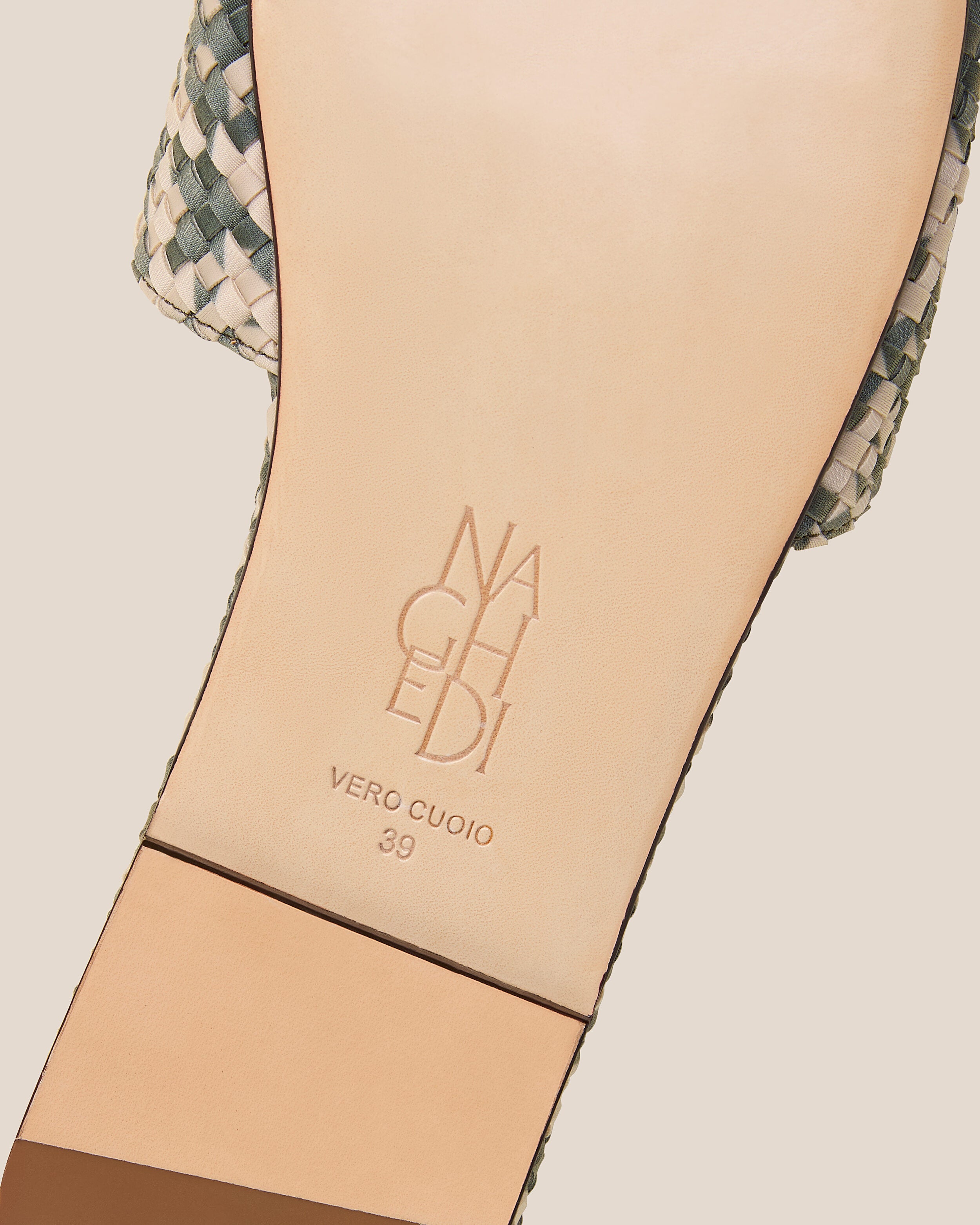 Shoe sole showing natural buffed leather sole, stamped NAGHEDI logo and size detail for The St. Barths Slide in Papyrus.