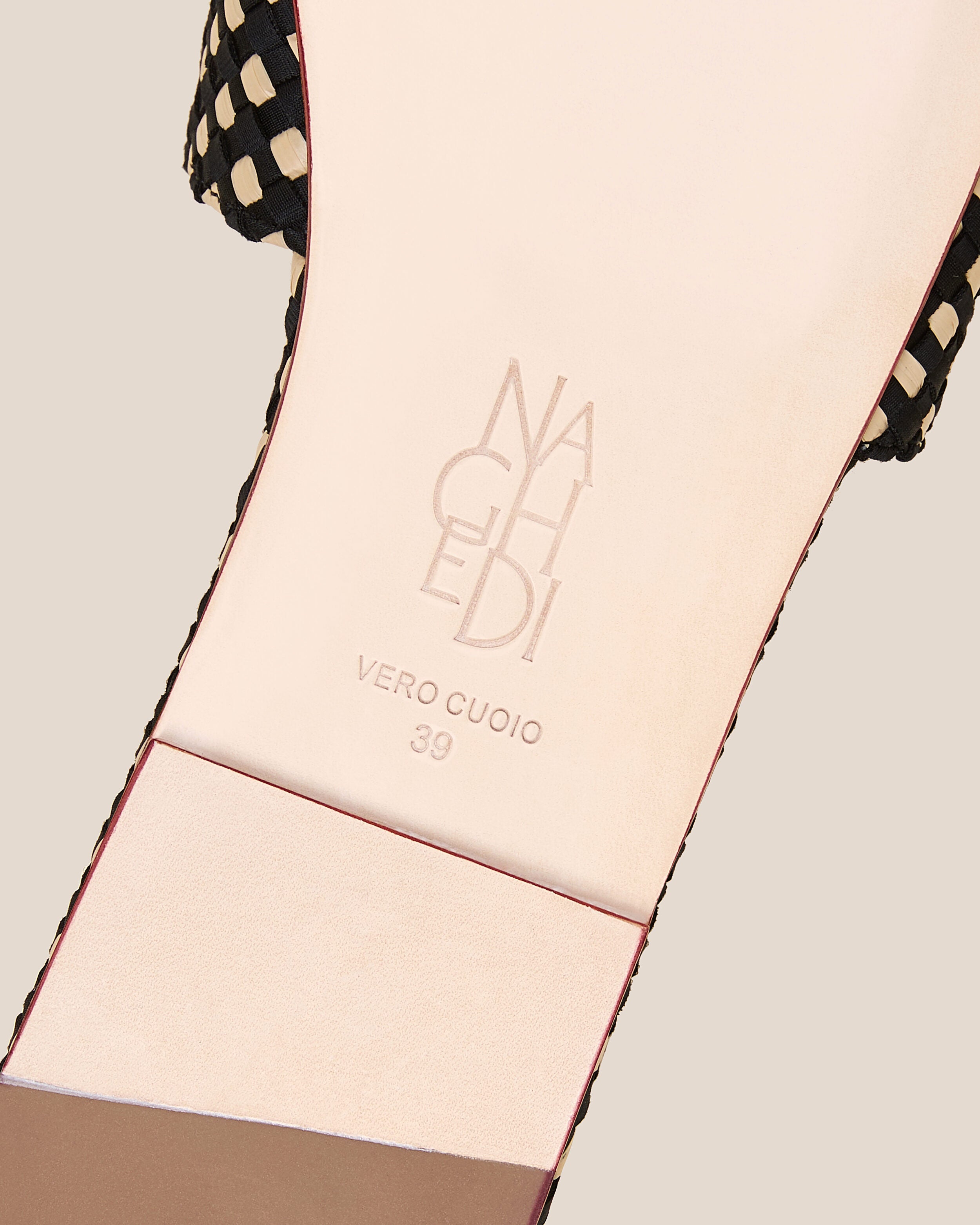 Shoe sole showing natural buffed leather sole, stamped NAGHEDI logo and size detail for The St. Barths Slide in Costa.