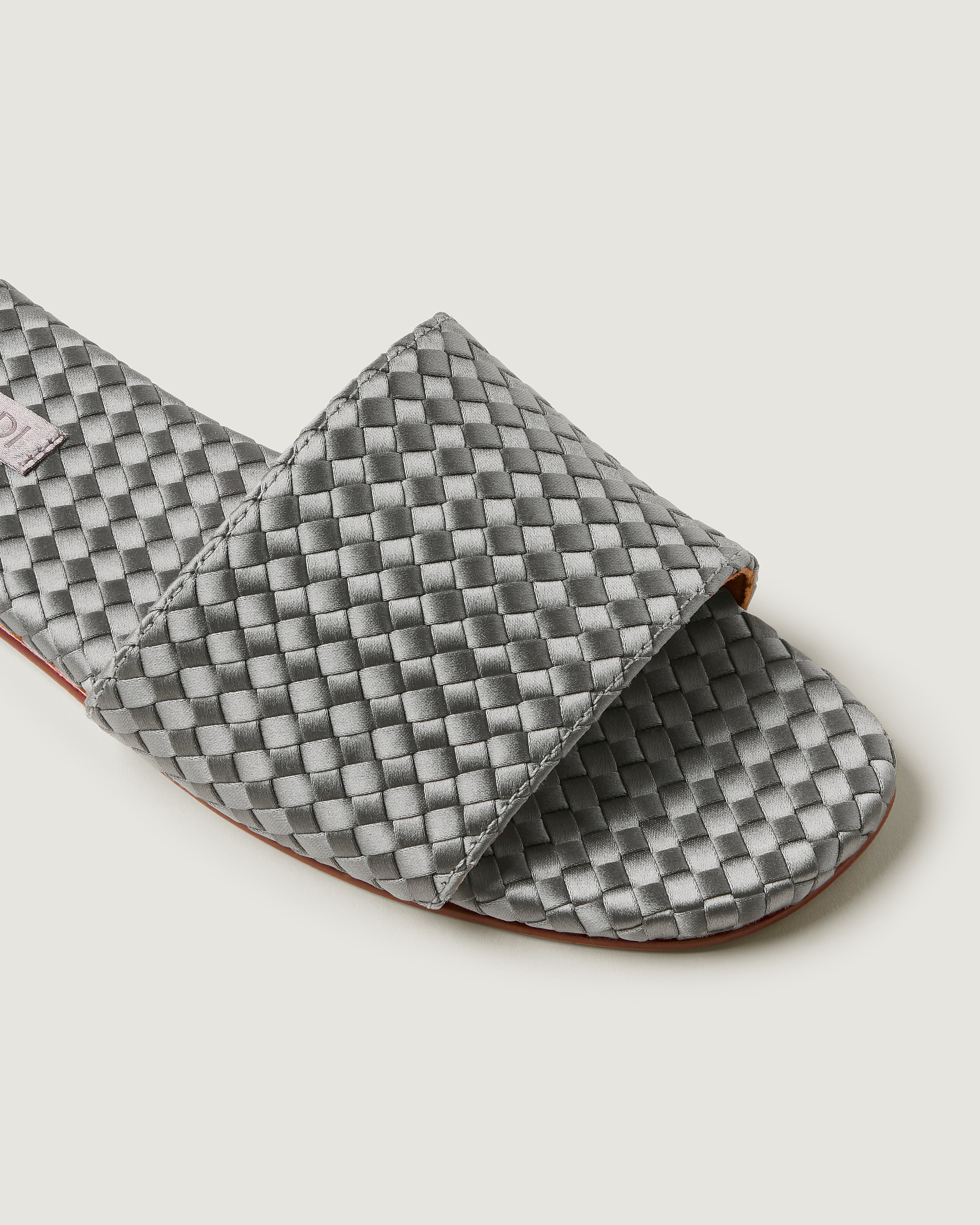 Close-up of The St. Barths Slide in Graphite showing its open toe and square silhouette.