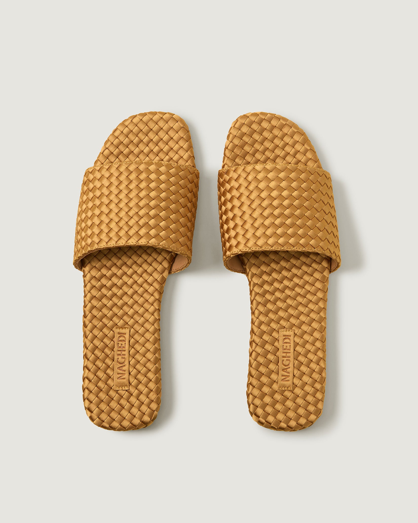 Top view of pair of St. Barths Satin Slide Sandals in Ore showing the handwoven neoprene insole.