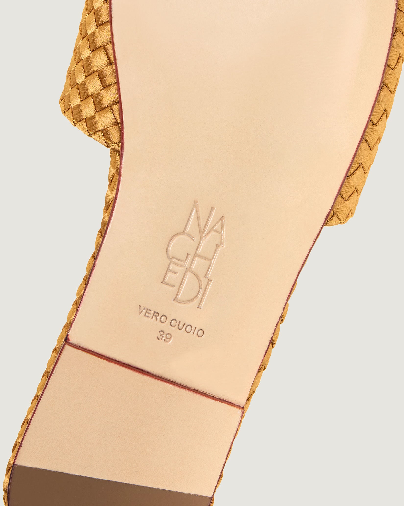 Shoe sole showing natural buffed leather sole, stamped NAGHEDI logo and size detail for St. Barths Satin Slide Sandals in Ore.