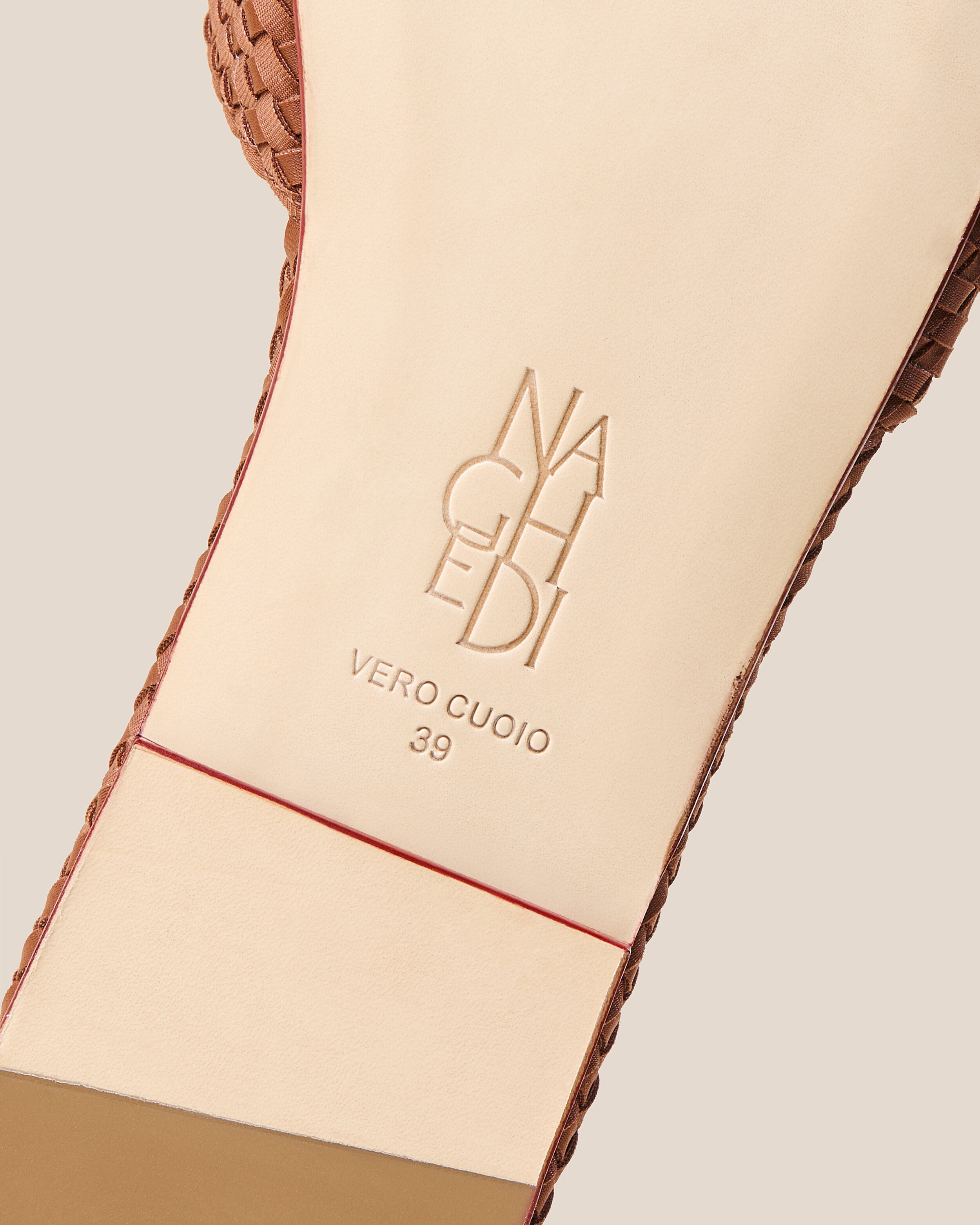 Shoe sole showing natural buffed leather sole, stamped NAGHEDI logo and size detail for The St. Barths Slide in Adobe.