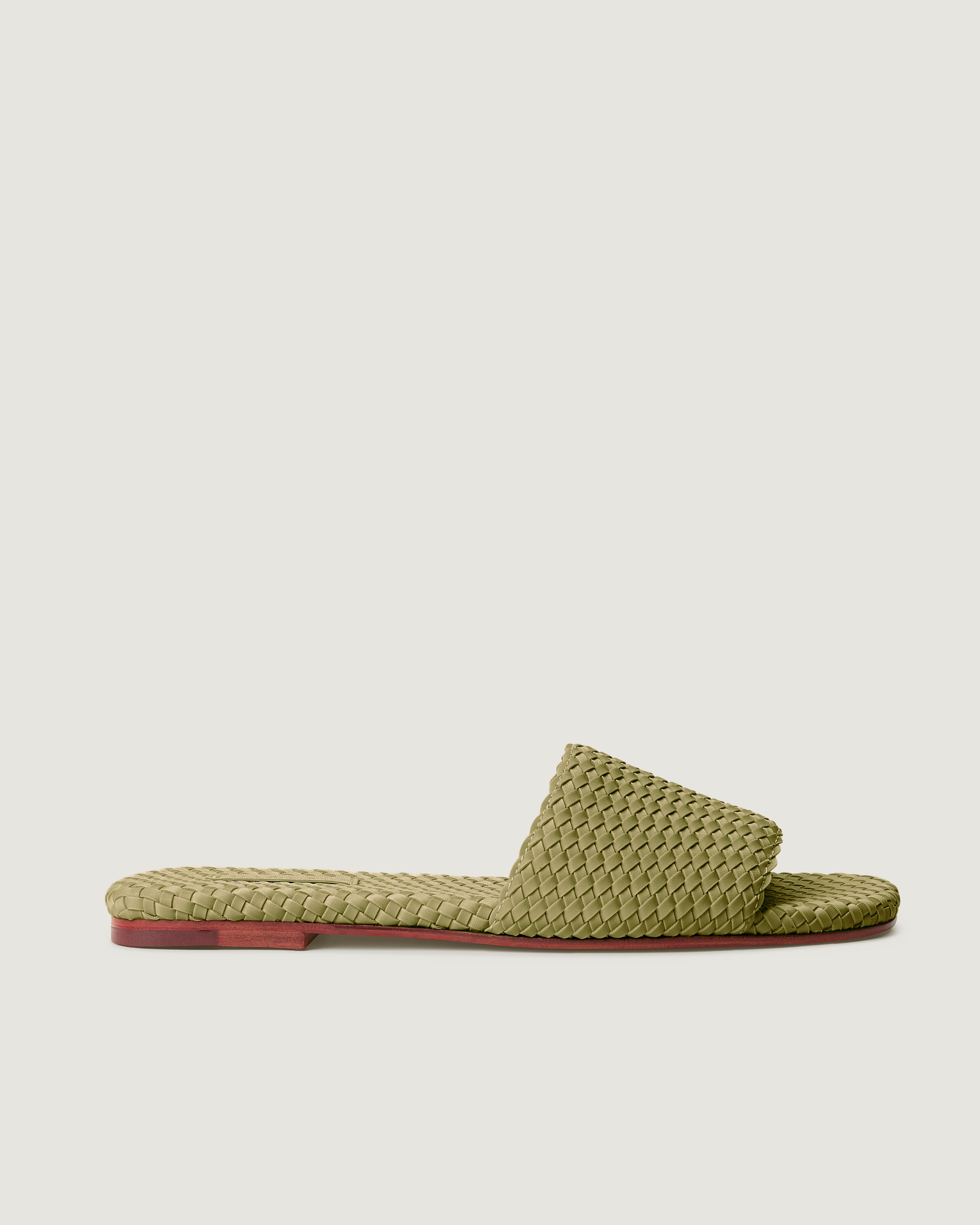 Side view of The St. Barths Slide in muted Bottle Green, featuring an open toe and square silhouette.